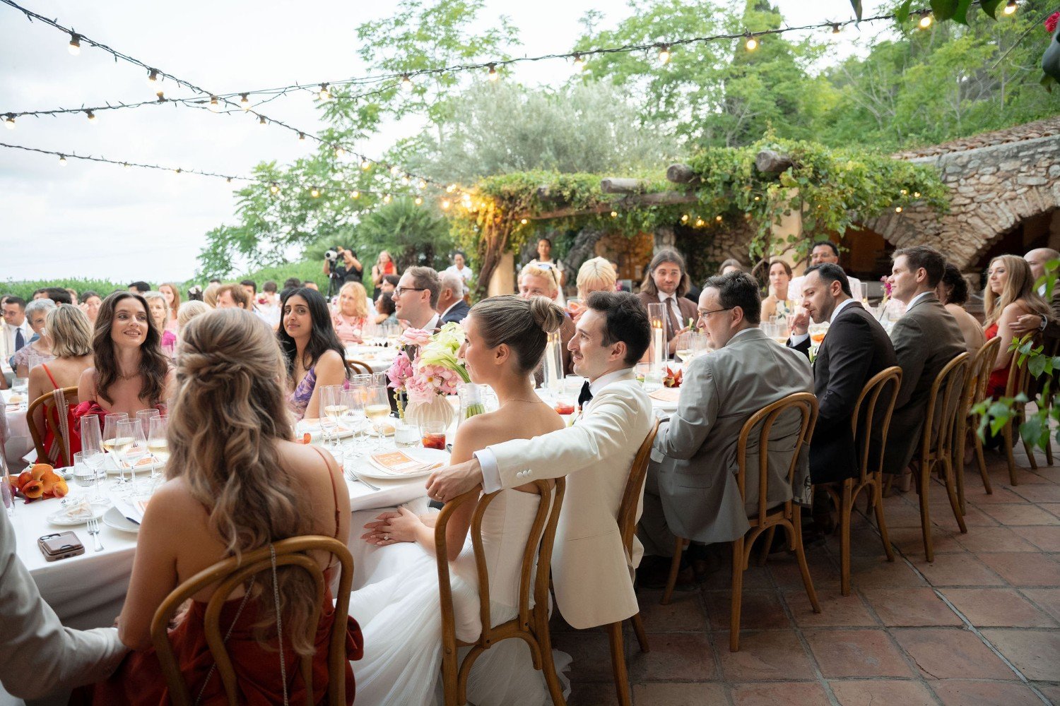 Couple listening to wedding speeches with their guests during dinner at Almiral de la Font in Barcelona