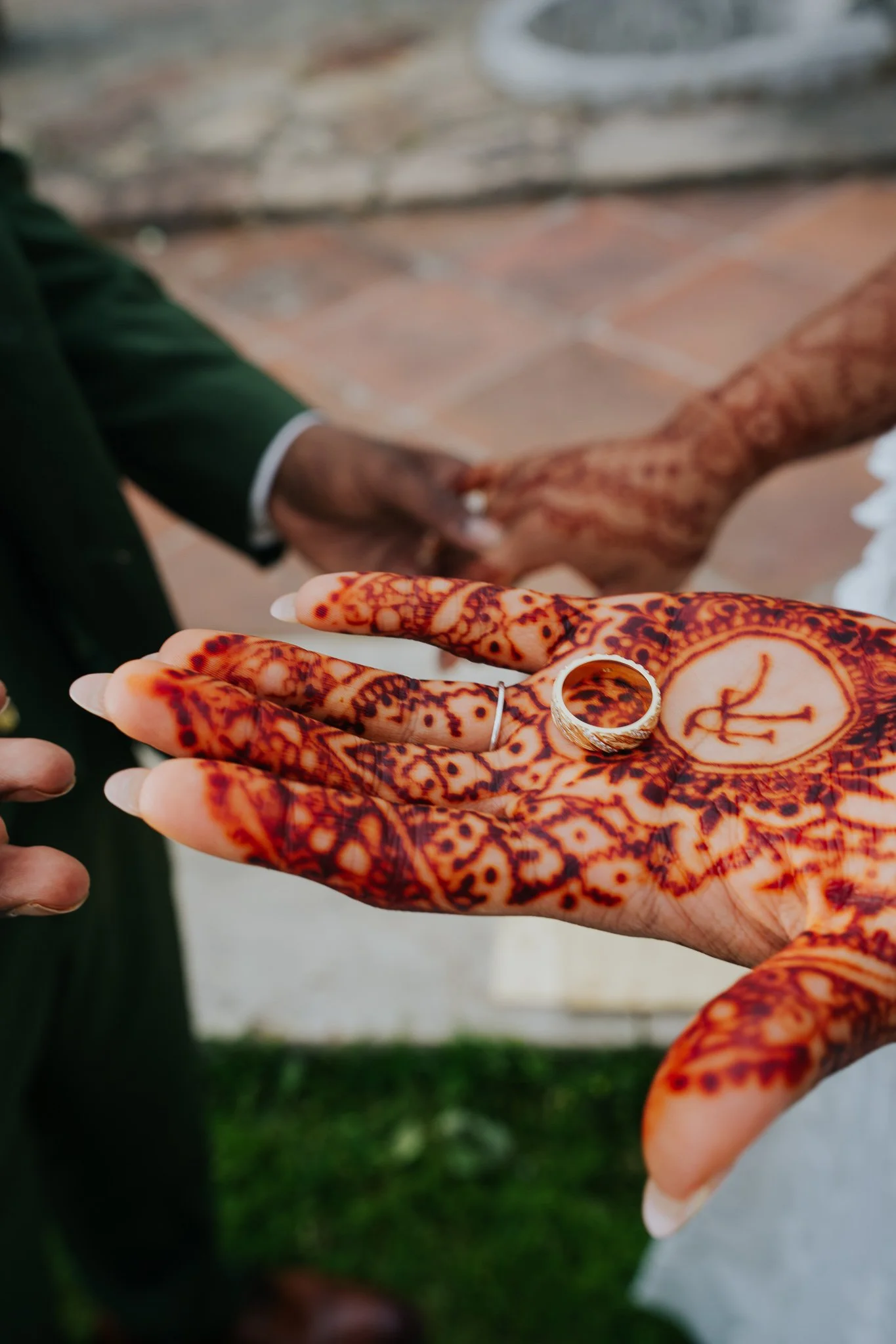 Close-up of a henna-decorated hand wearing a wedding ring.