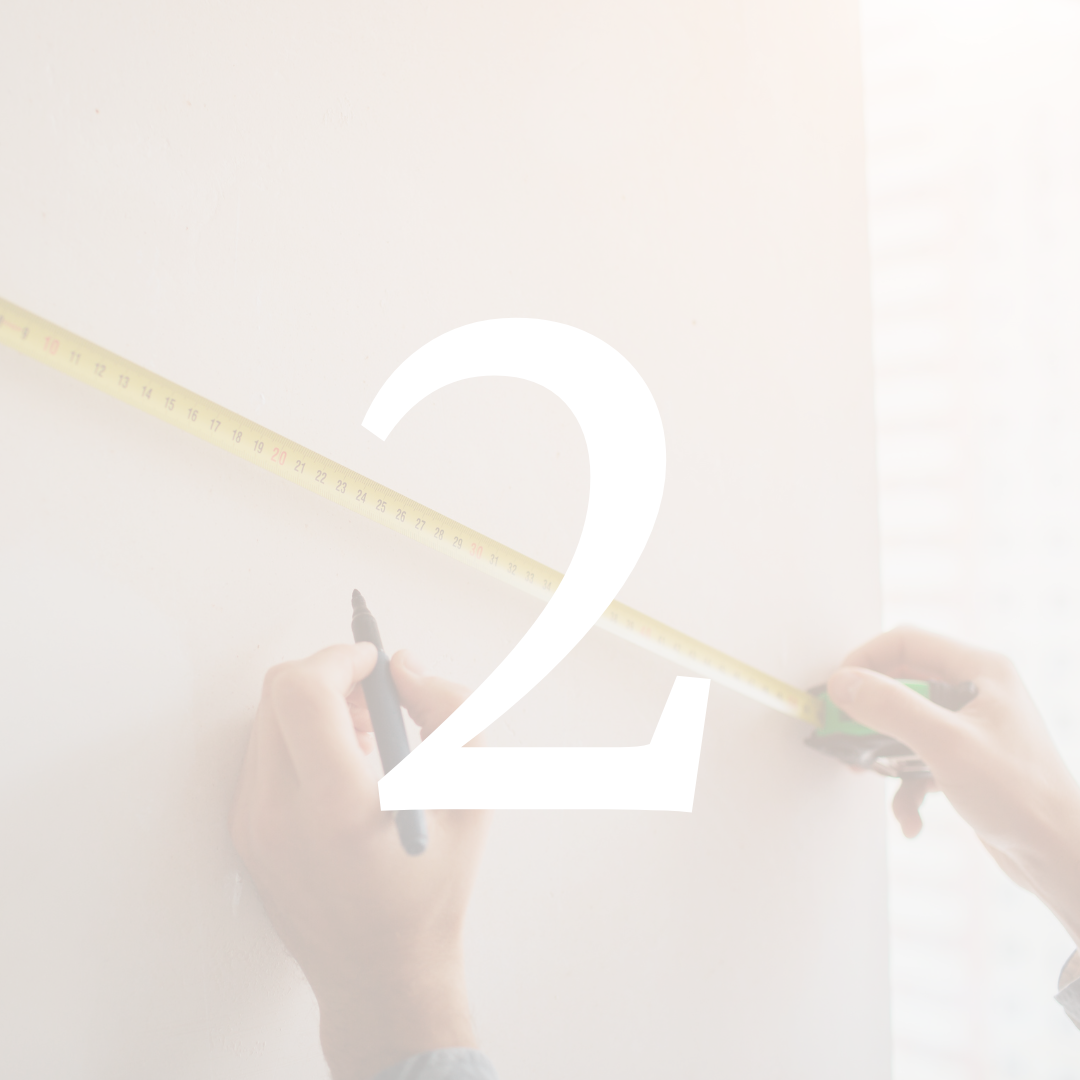 Hands holding measuring tape against white wall