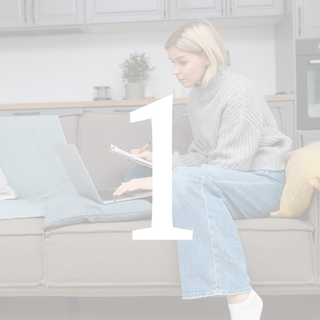 Person sitting on a sofa using a laptop, holding a clipboard, wearing a gray sweater and jeans, large white number 1 overlay.