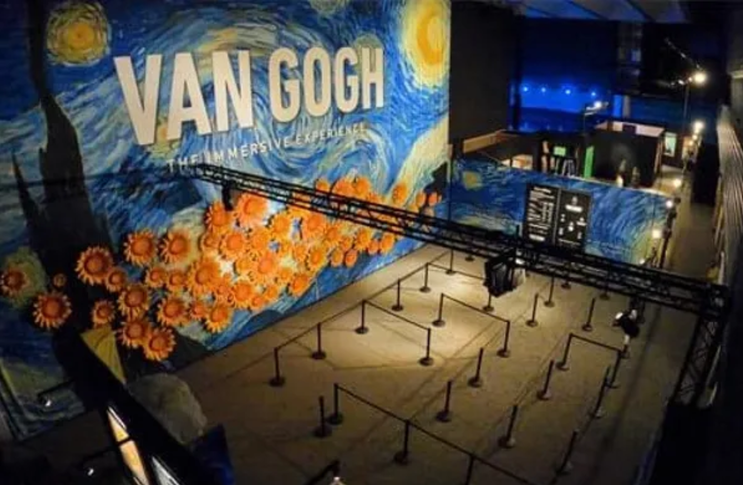 Van Gogh immersive experience exhibit with Starry Night and sunflowers artwork.