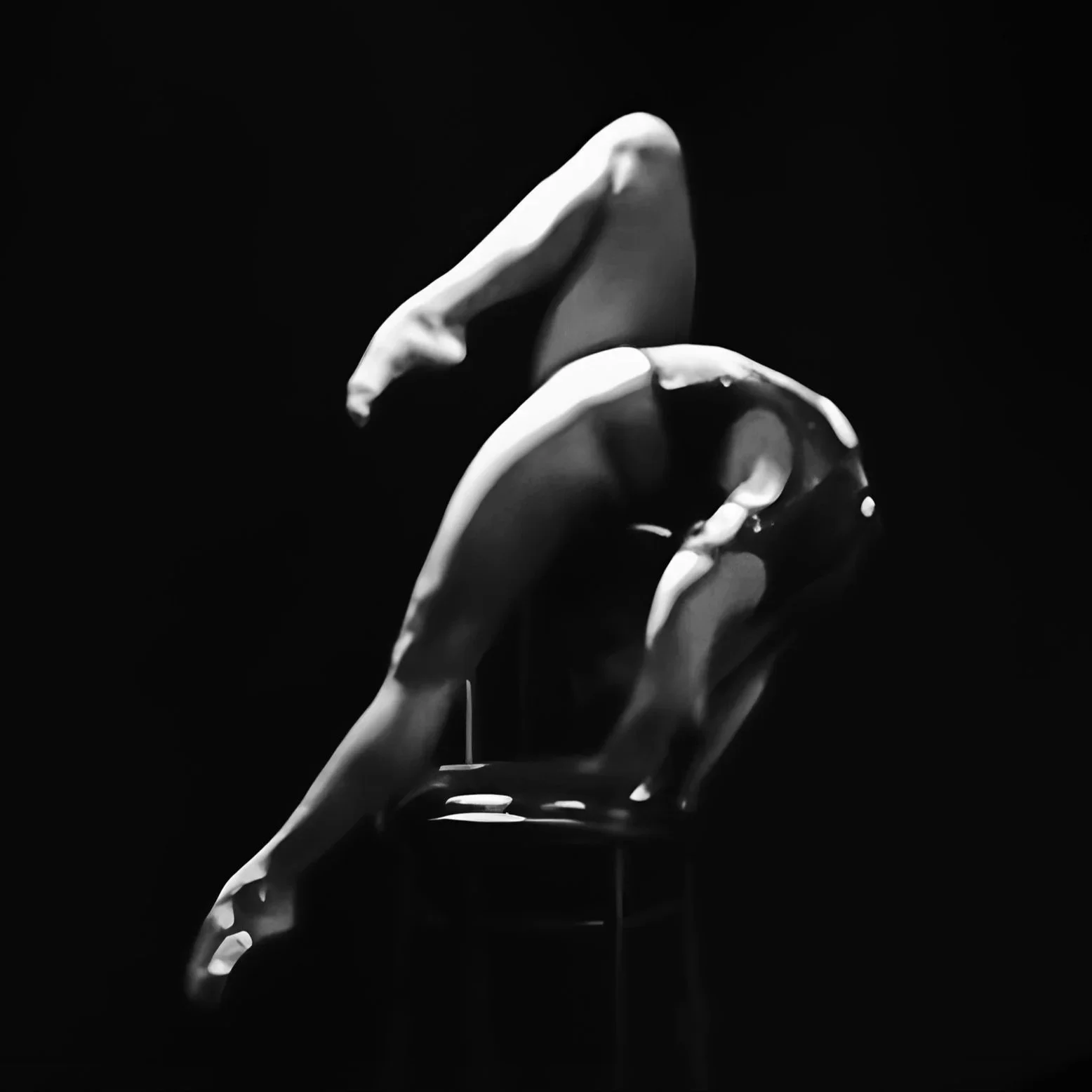 A black and white photo of a hand sculpture with water droplets, with a dark background.