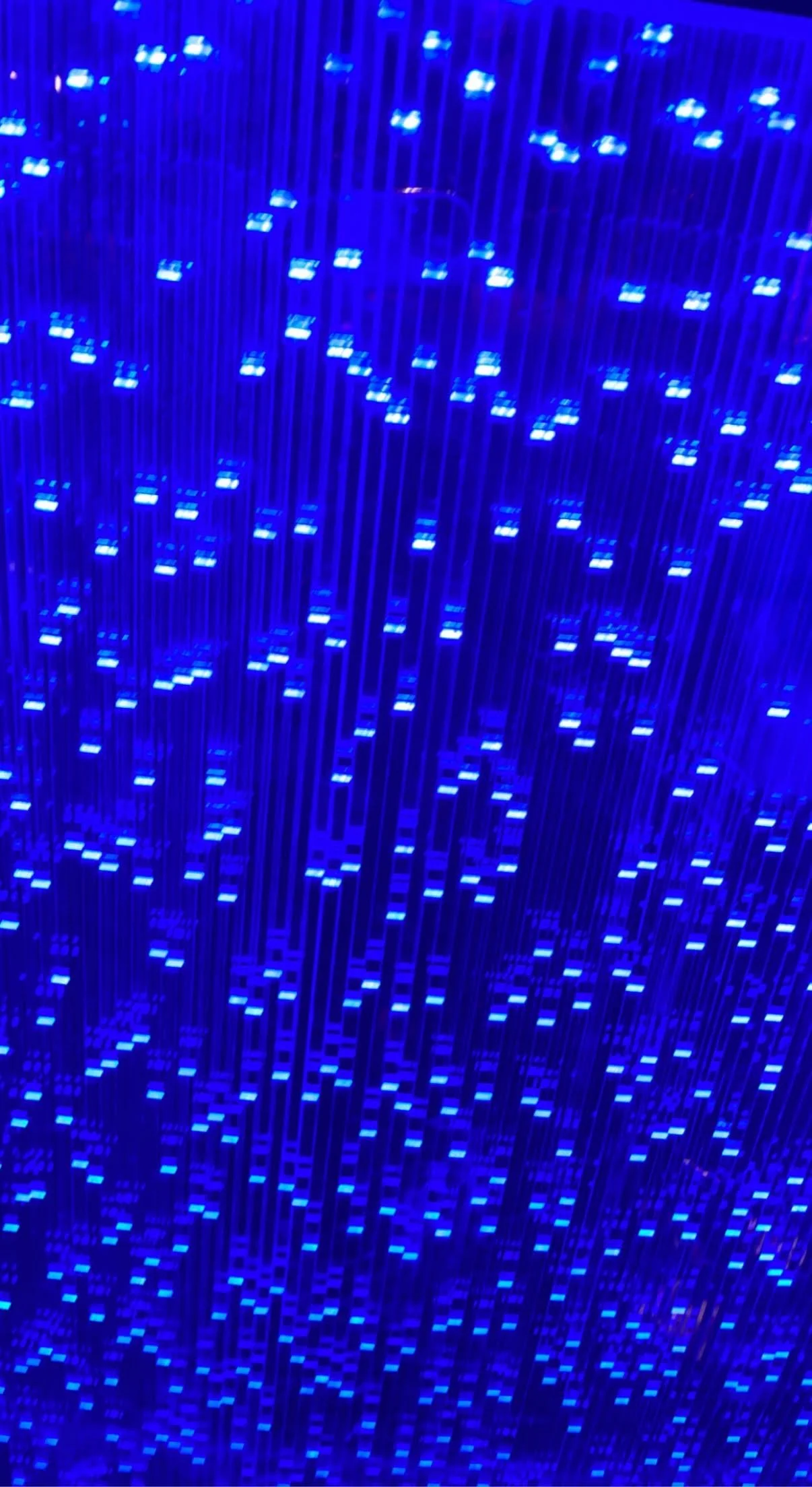 Blue LED lights and rods arranged in a pattern, resembling a digital or technological display.
