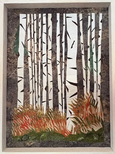 Paper cutout art of a forest scene with tall trees and bushes at the bottom, framed by a gray border.