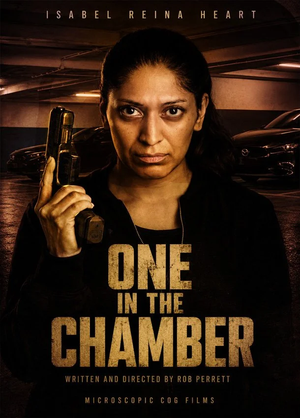 Poster for the film "One in the Chamber" featuring a woman with dark hair holding a gun and looking serious, set against a dimly lit parking garage.