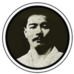 Black and white photo of a man with short hair, wearing a light-colored shirt, inside a circular frame.