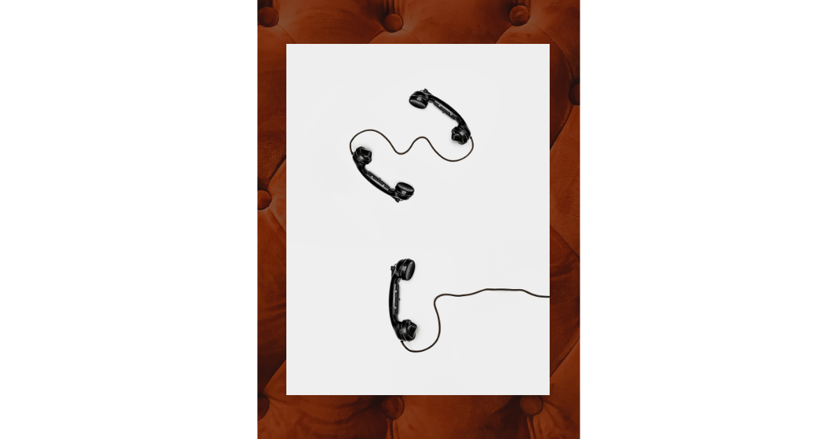 Disconnected black rotary telephones connected by a cord, symbolizing strained or distant communication.