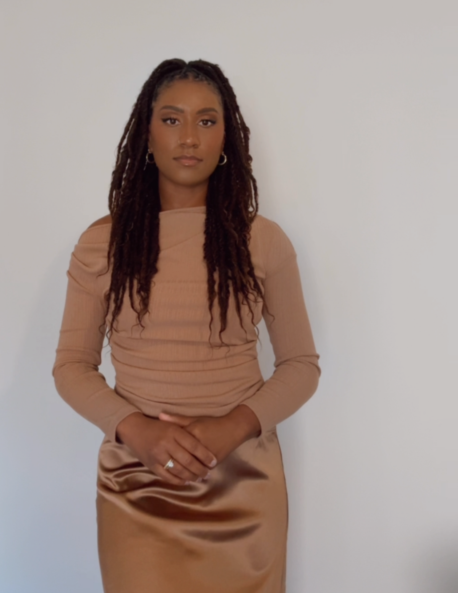 Portrait of a confident Black woman therapist in tan attire, grounded and approachable, your guide through complex emotional healing.