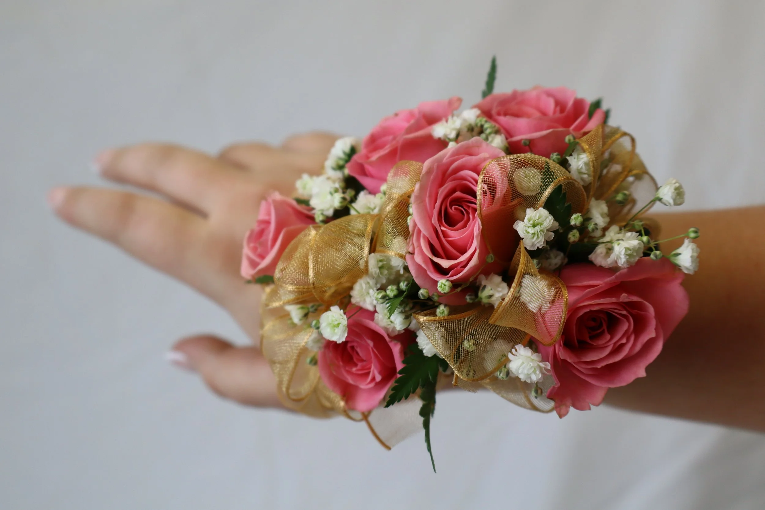 Rose corsage with spray roses and baby’s breath worn on wrist for prom
