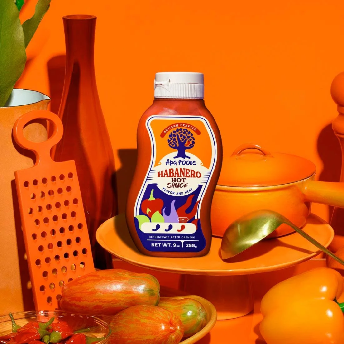 Una botella de salsa de habanero caliente en un fondo de color naranja, rodeada de objetos y alimentos en tonos naranjas y verdes, incluyendo frutas y utensilios de cocina.