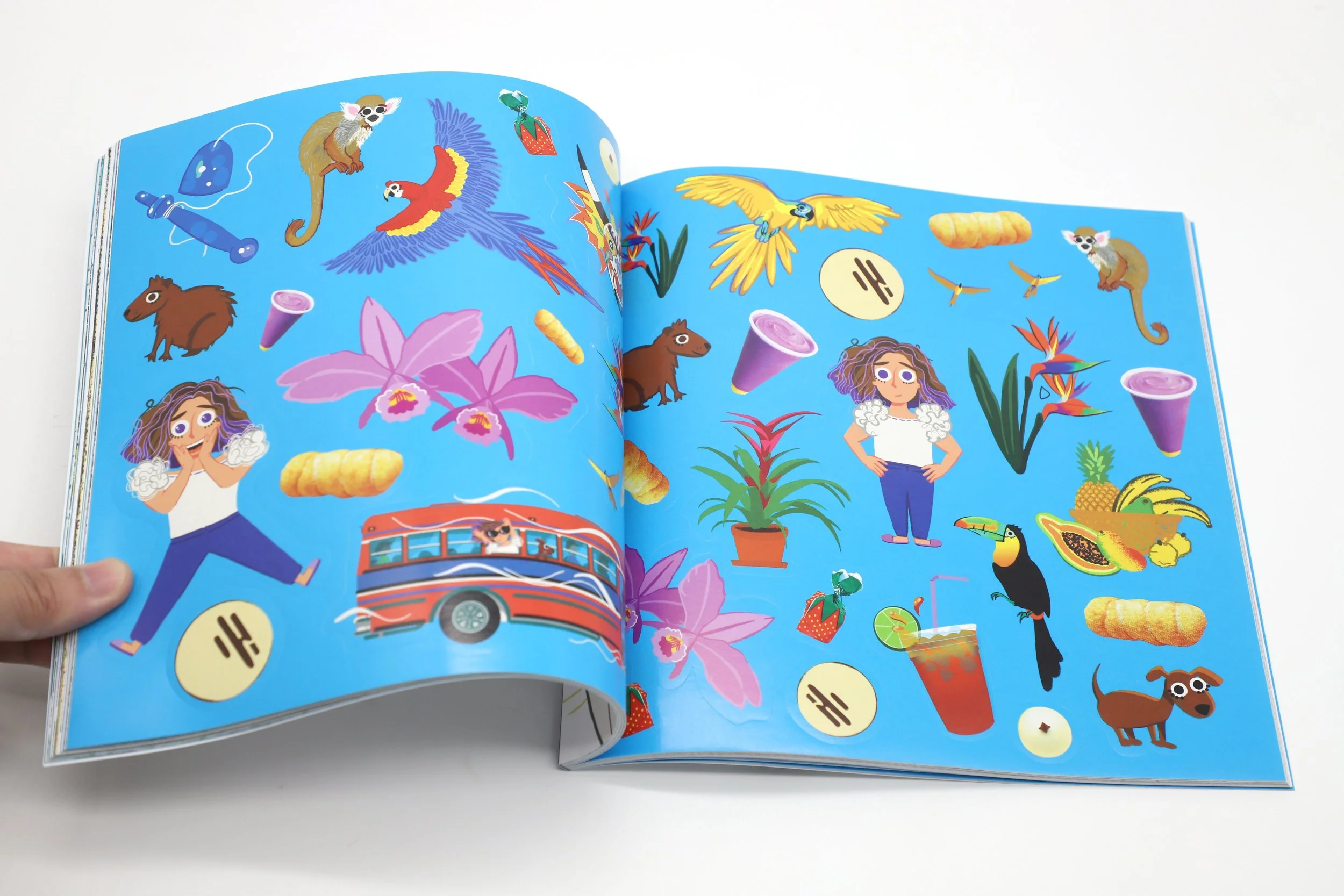 Ilustraciones coloridas de diferentes objetos y animales en un libro, incluyendo plantas, aves, perros, un autobús, una mujer, comida y objetos diversos sobre un fondo azul.