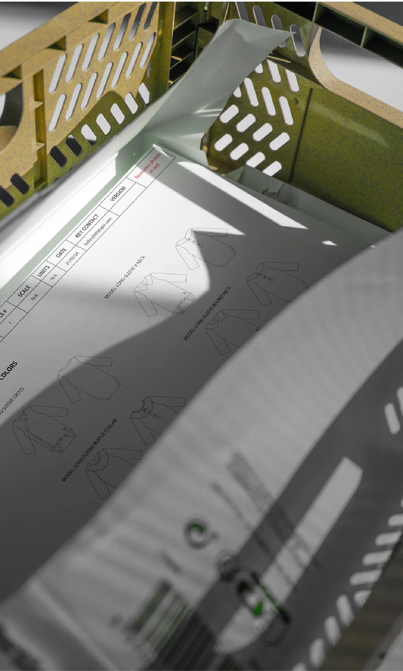 Instrucciones para ensamblar una chaqueta de manga larga en un folleto, dentro de una caja de transporte.