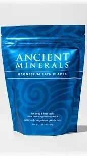Blue resealable bag of Ancient Minerals Magnesium Bath Flakes with text indicating it's for relaxing and nourishing the skin.