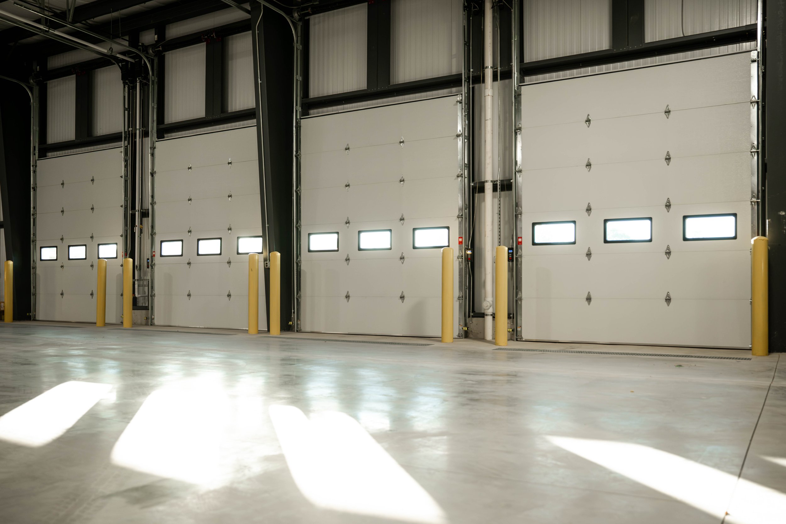 Interior view of the overhead doors and exposed steel framing inside the Weller Auto warehouse addition
