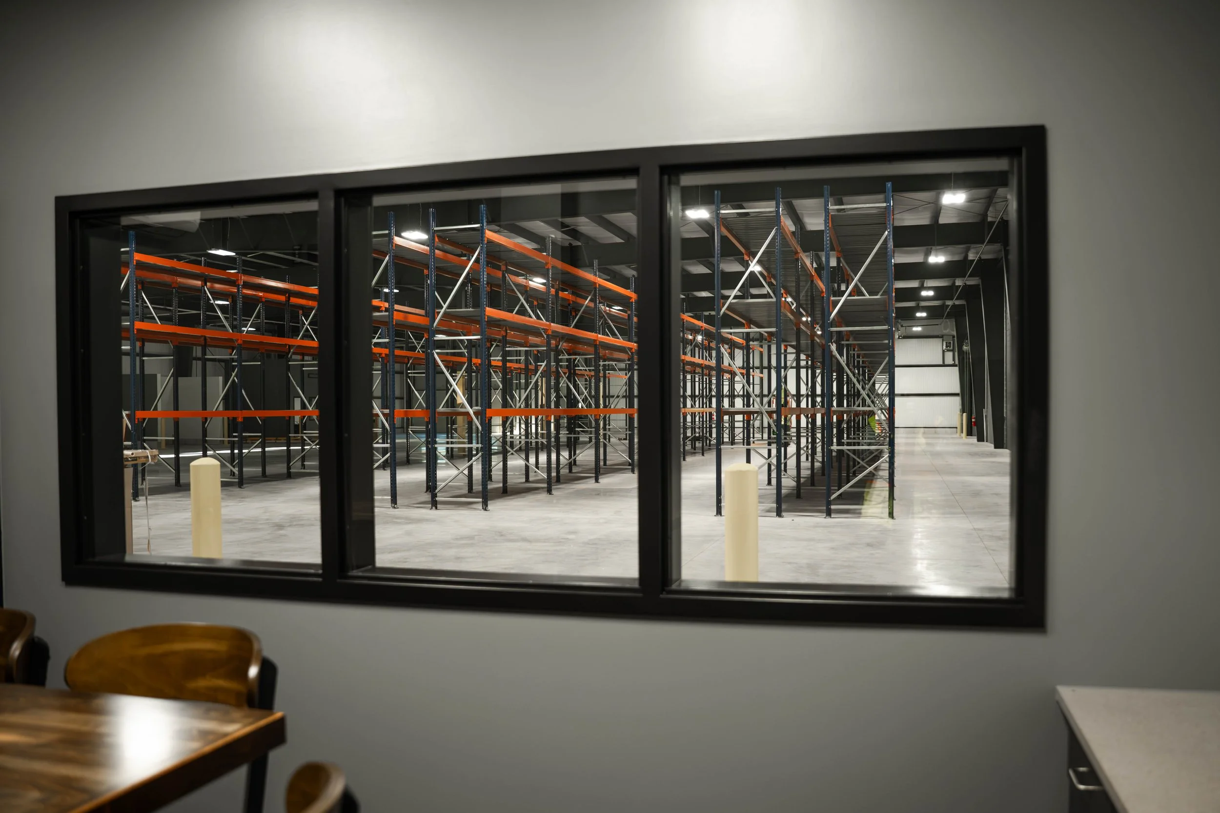 Interior window looking from the new office space onto warehouse racking at Weller Auto