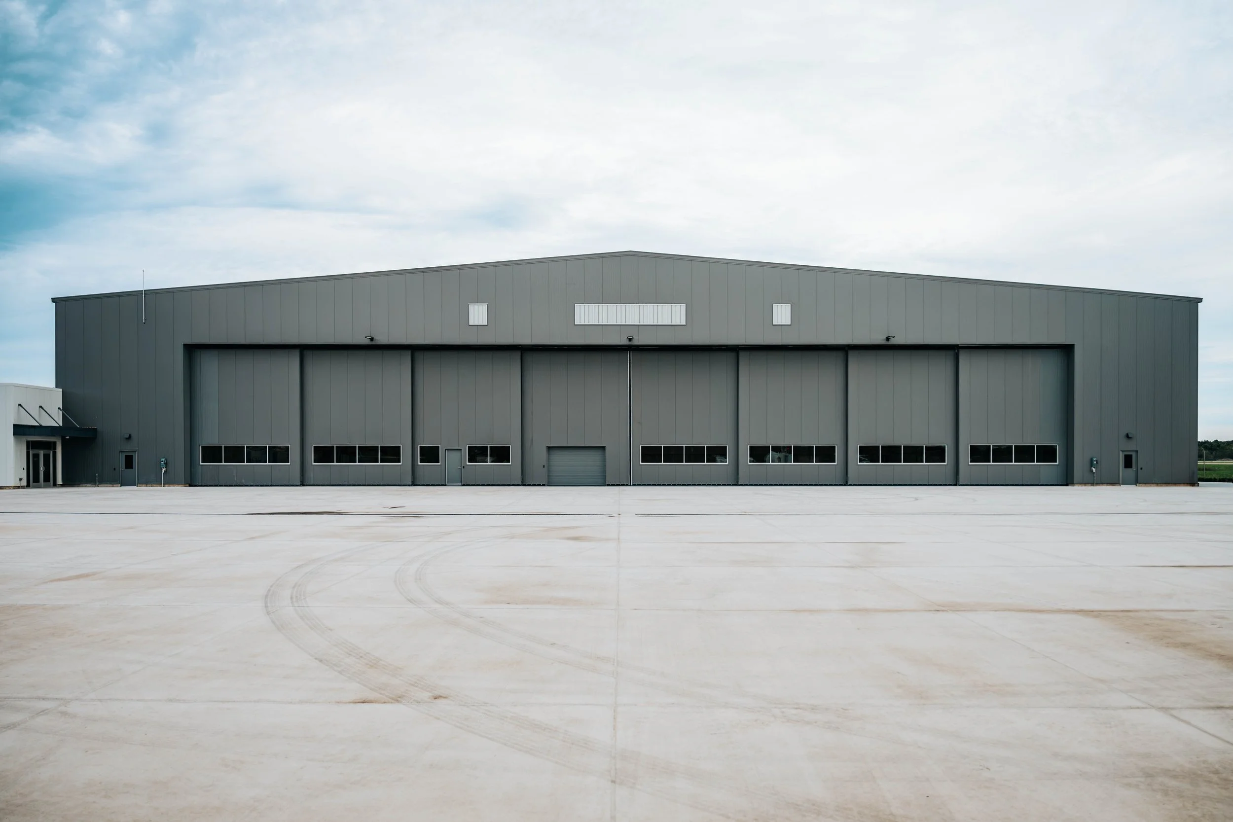 Stryker Sky High hangar exterior with the hangar door closed and a concrete apron in front