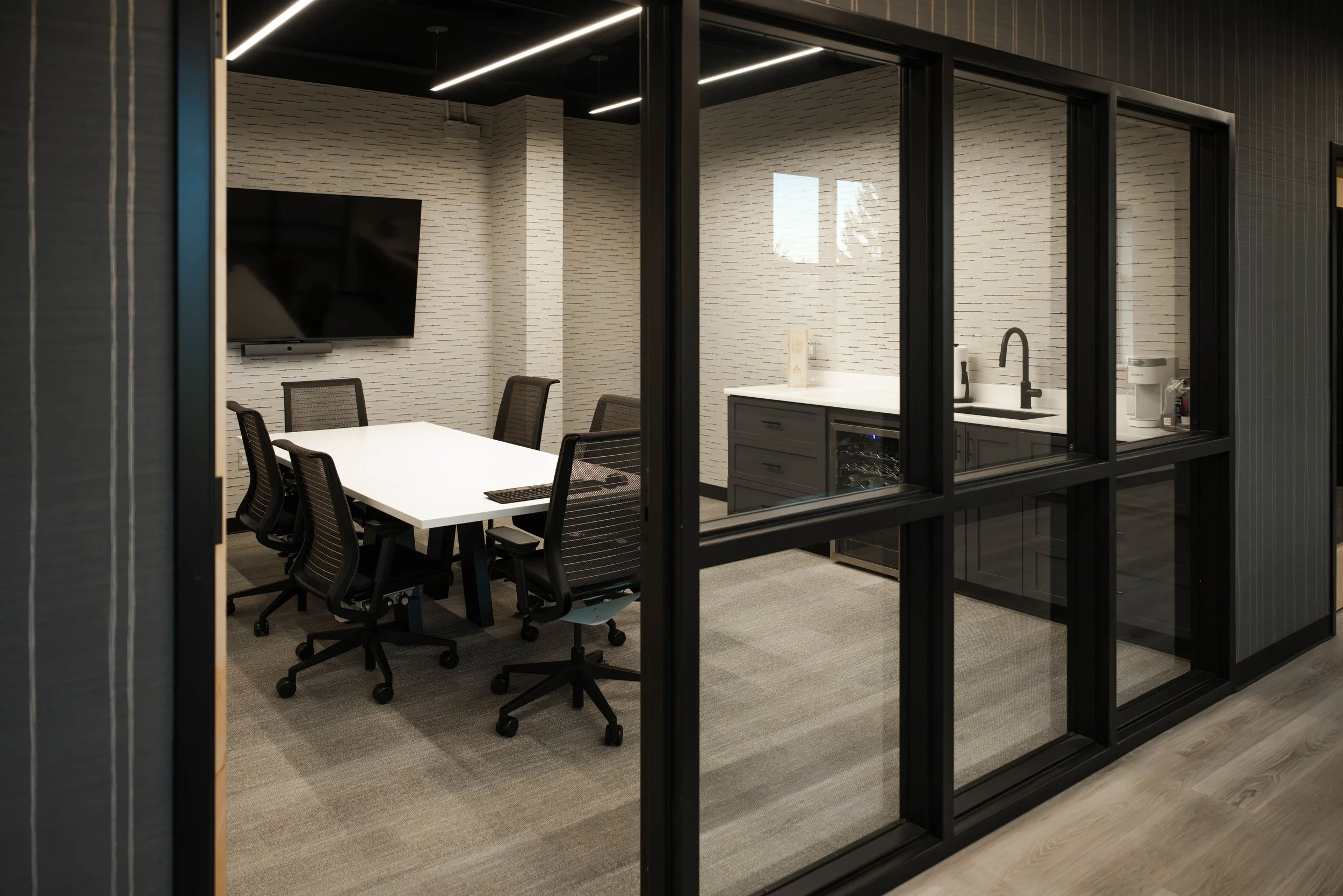New conference room at AFX behind a black-framed glass wall.