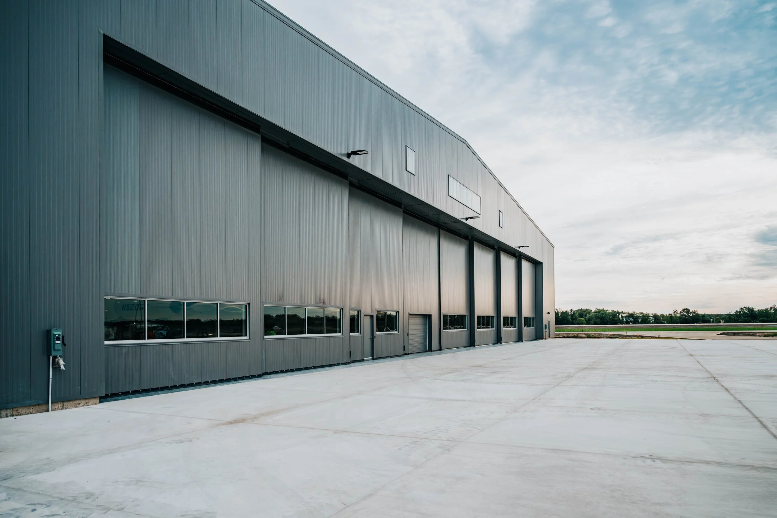 Side view of the Stryker Sky High hangar exterior with metal wall panels and the hangar door closed