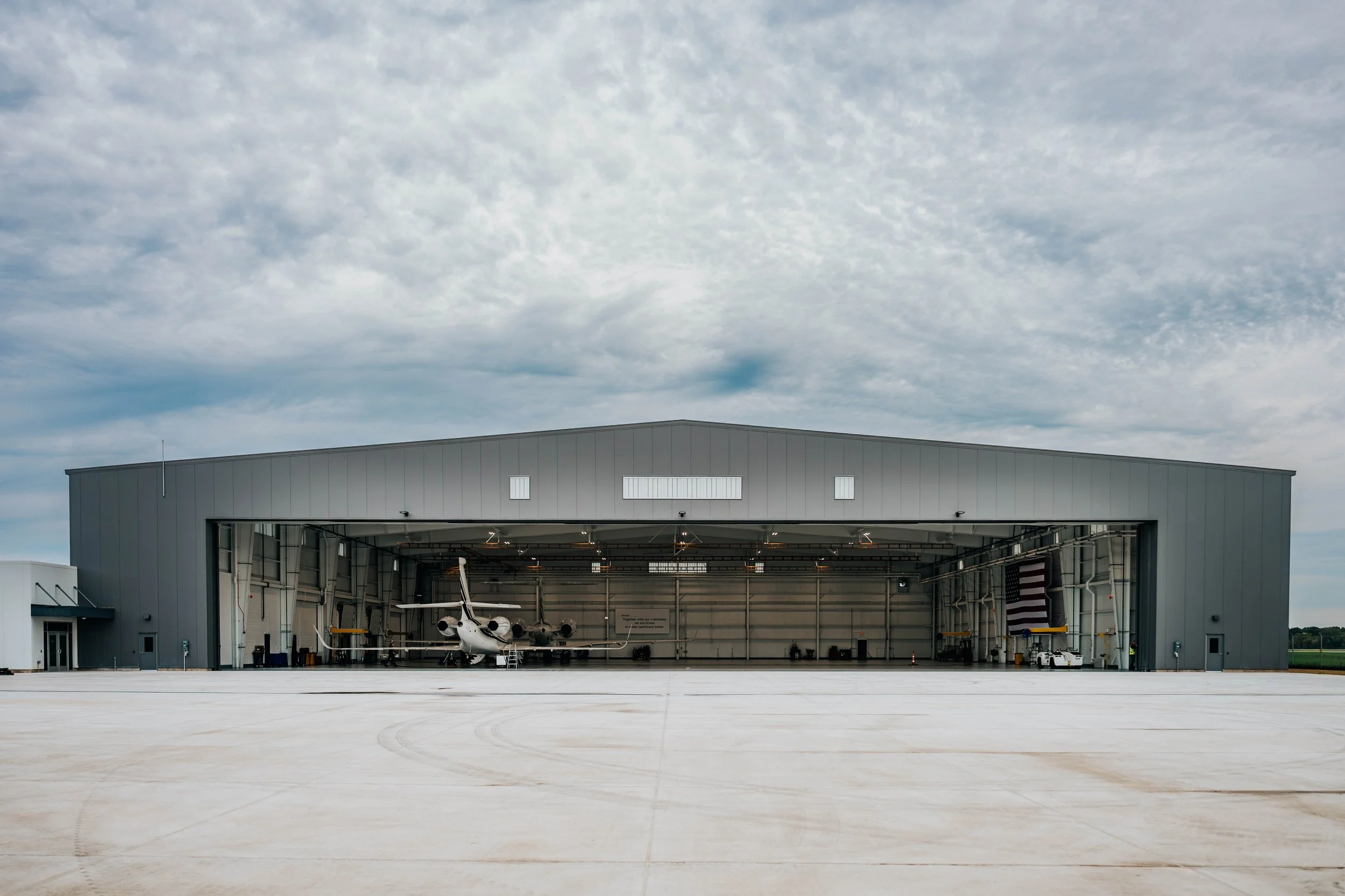 Front of the Stryker Sky High hangar with the hangar door fully open and a corporate jet inside