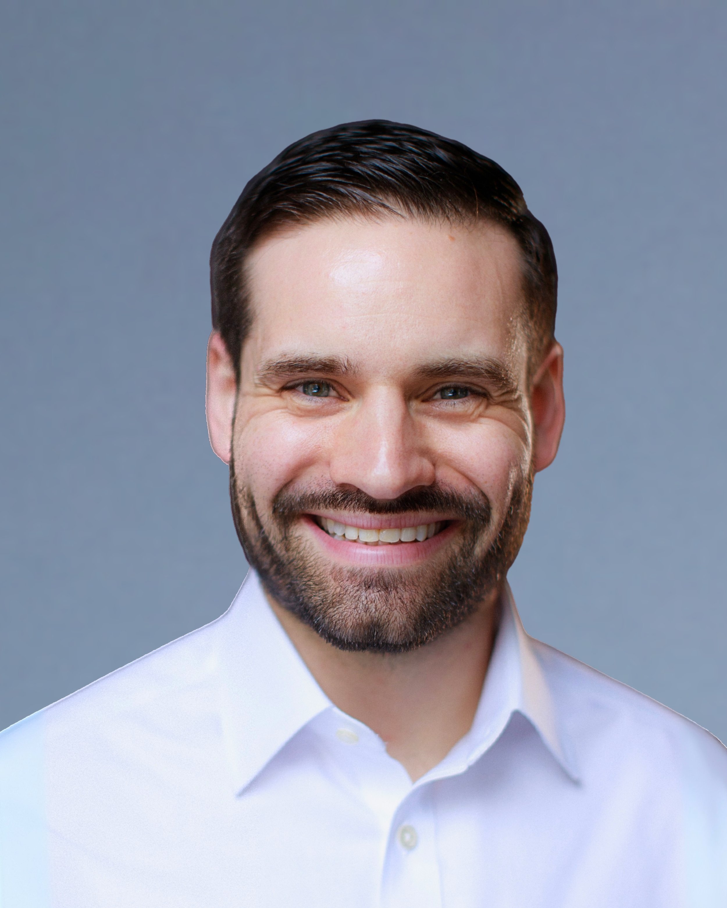 Close-up of a smiling man with dark brown hair and a beard, wearing a white shirt, against a gray background.