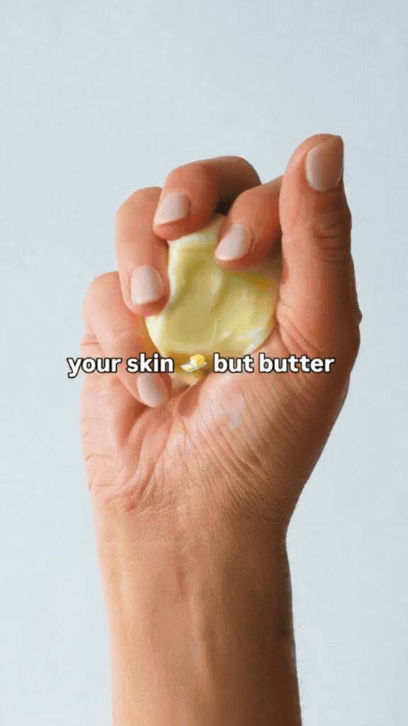 Close-up of a hand squeezing a tablespoon of butter, with text overlay that says 'your skin but butter'.