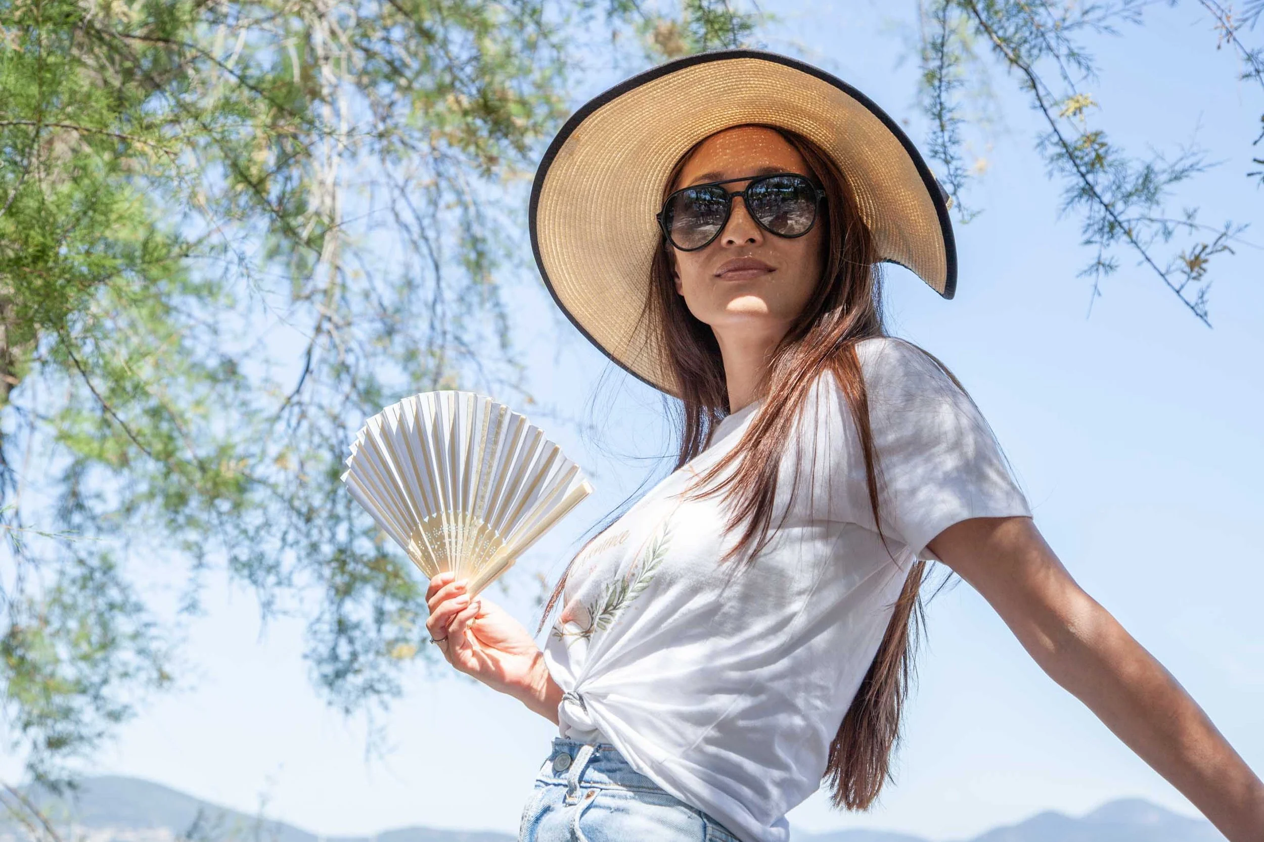 Portrait of the bride-to-be with sun hat, sunglasses and fan during a bachelorette photo session in the Gulf of Saint-Tropez