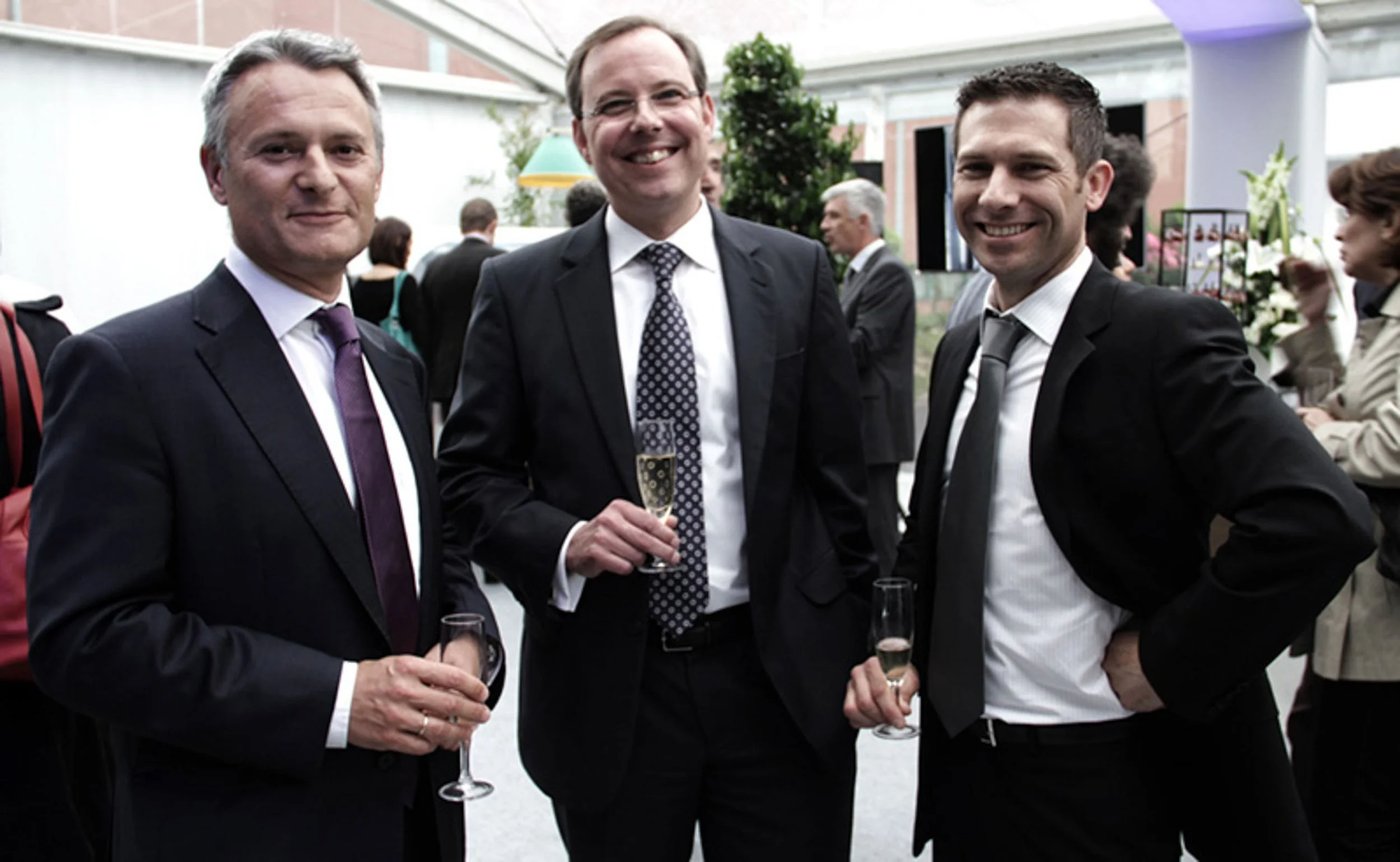 Photographe événement entreprise Golfe de Saint-Tropez — trois invités en costume lors d'une réception