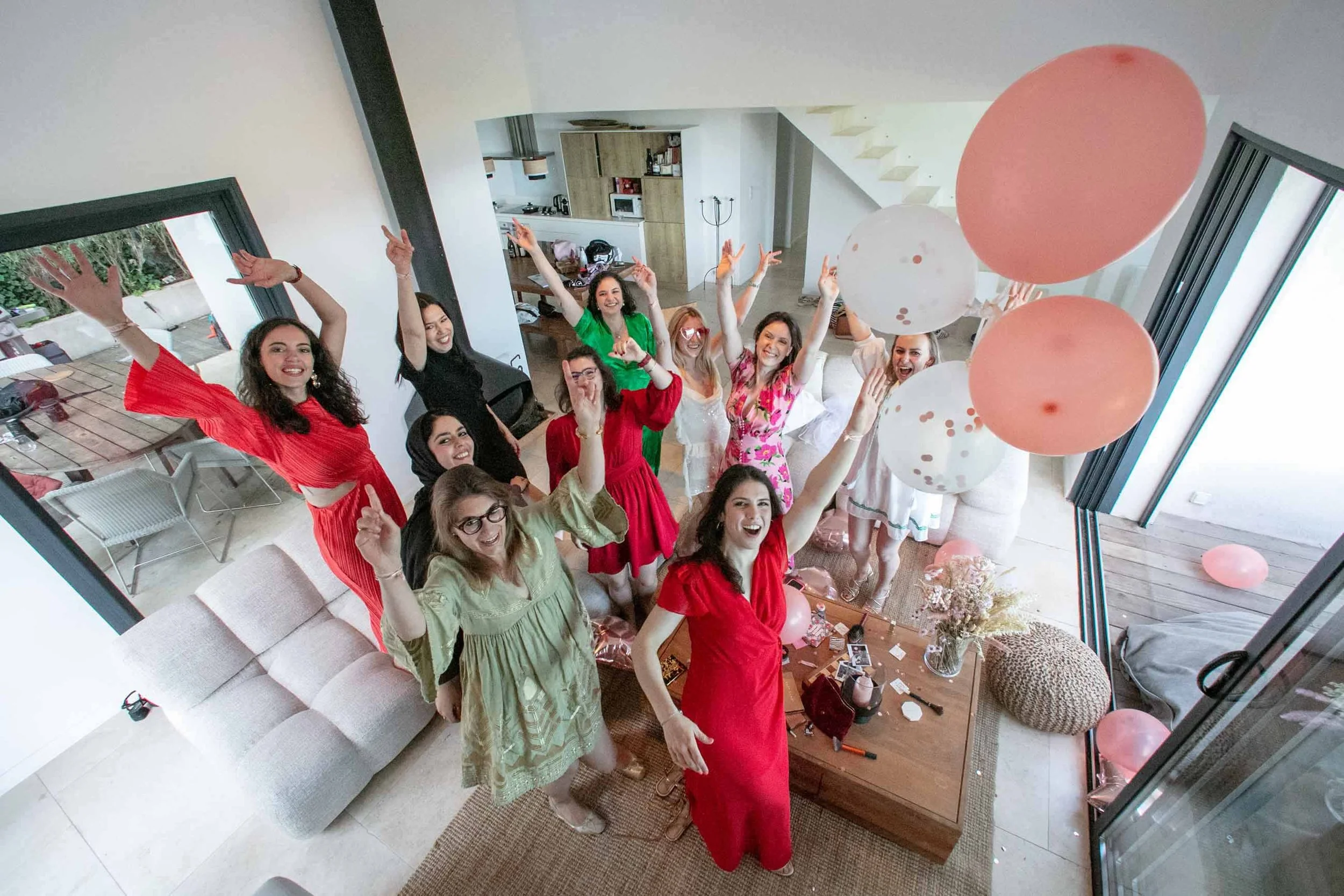 Friends celebrating with balloons in the living room of a modern villa during a hen party on the French Riviera