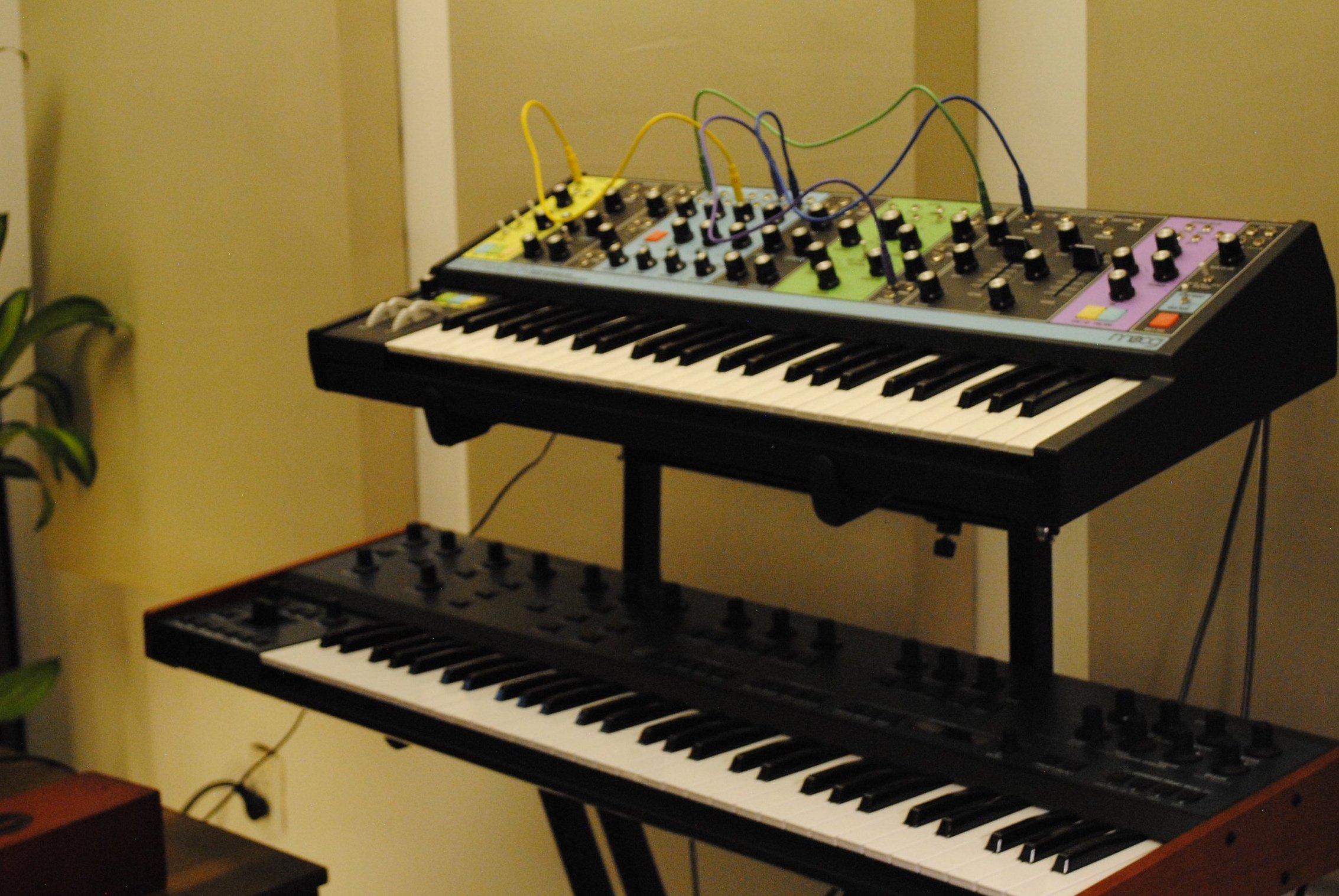 Teclados musicales con cables conectados en una sala de estudio o presentación.