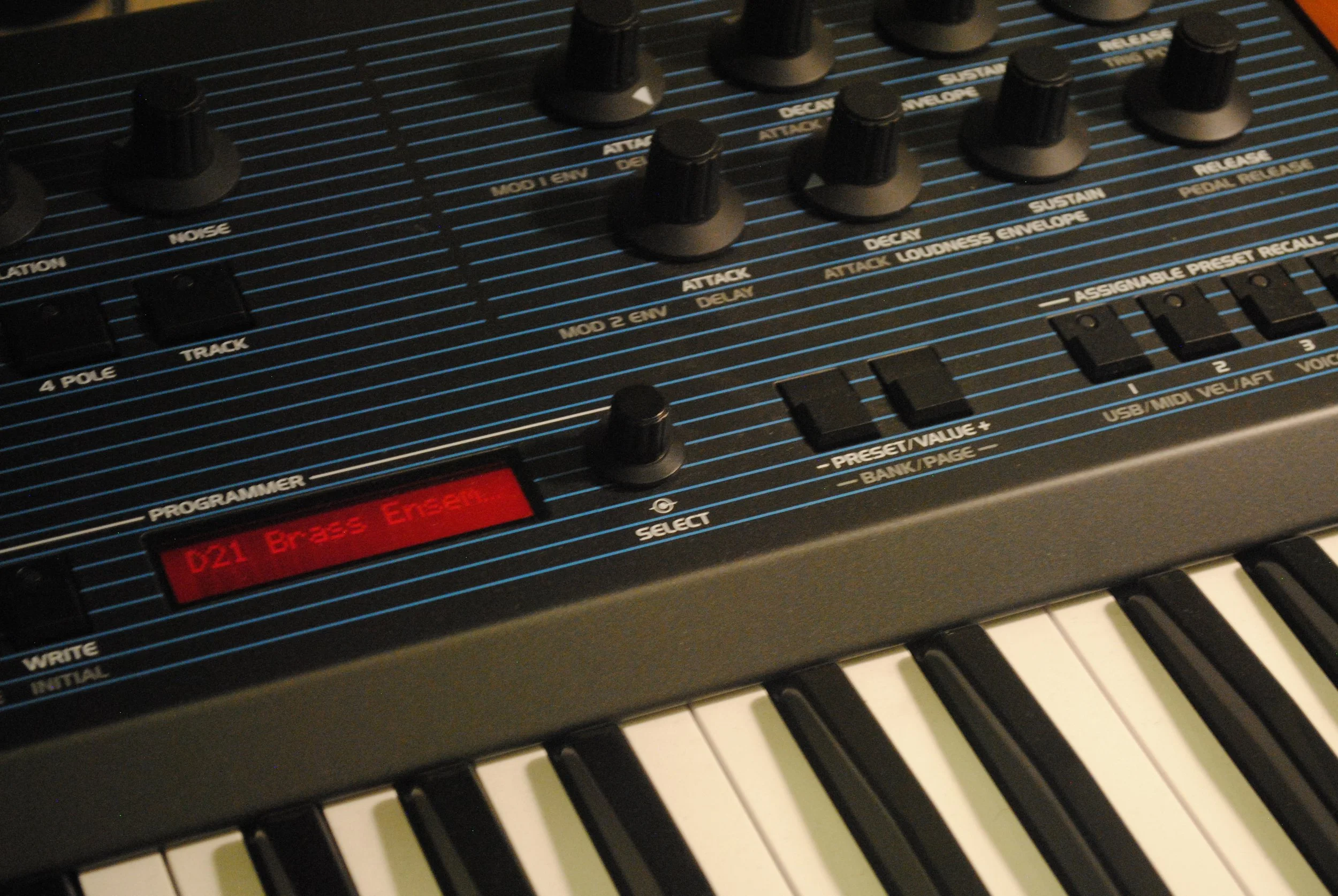 Teclado de sintetizador "PROPHET" con panel de control y pantalla digital con letras rojas.