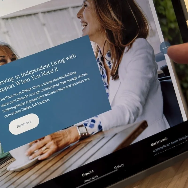 Close-up of a person scrolling on a tablet, showing a website of a senior living community.