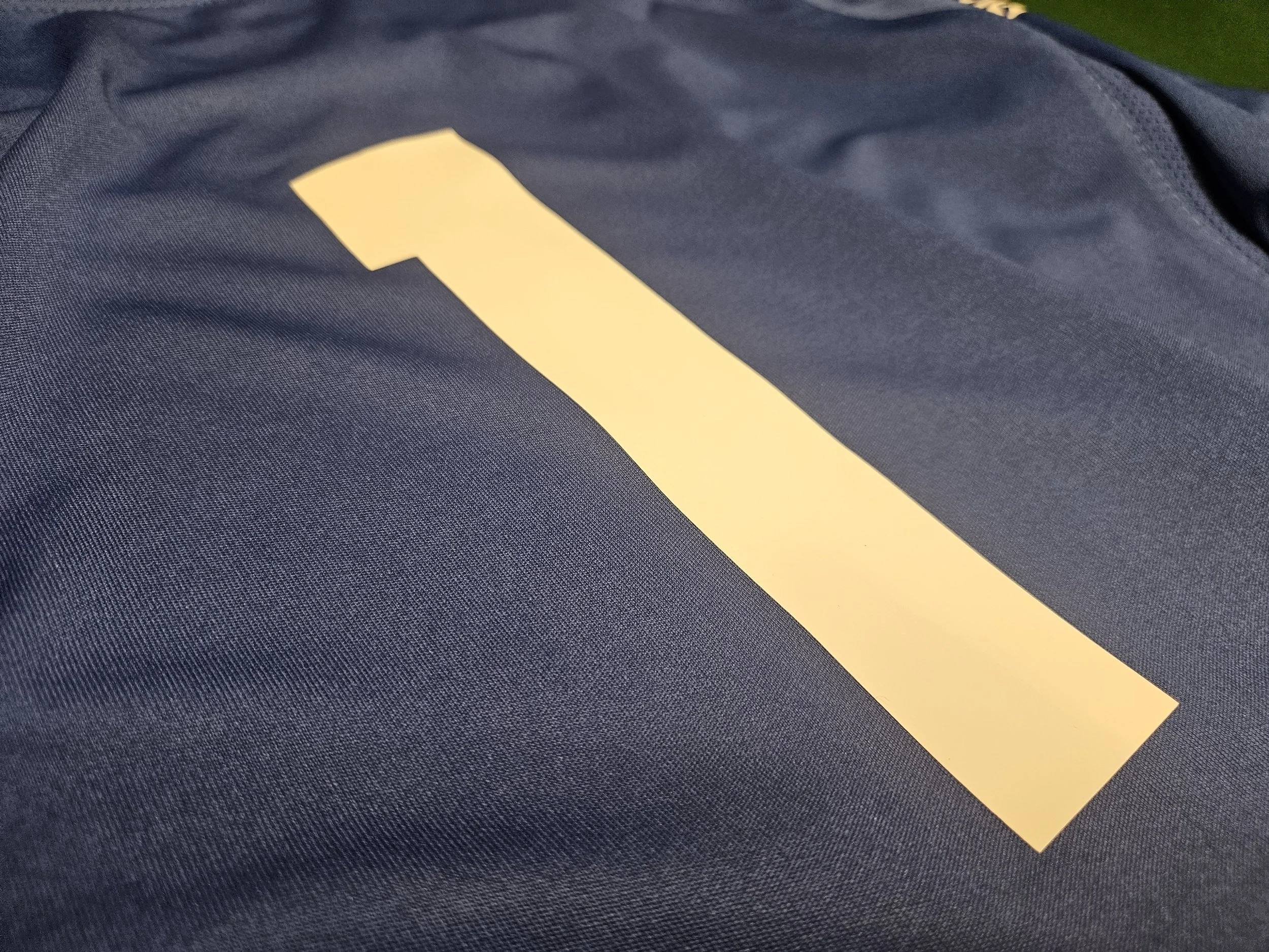 Close-up of a dark-colored fabric with a yellow stripe or tape on it.
