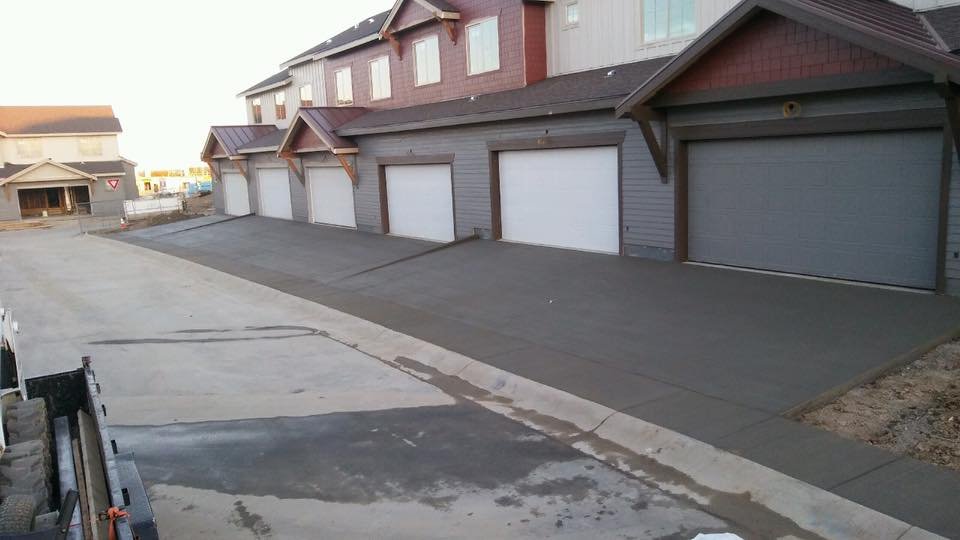 Townhouse complexes with multiple garage doors and freshly paved driveways.