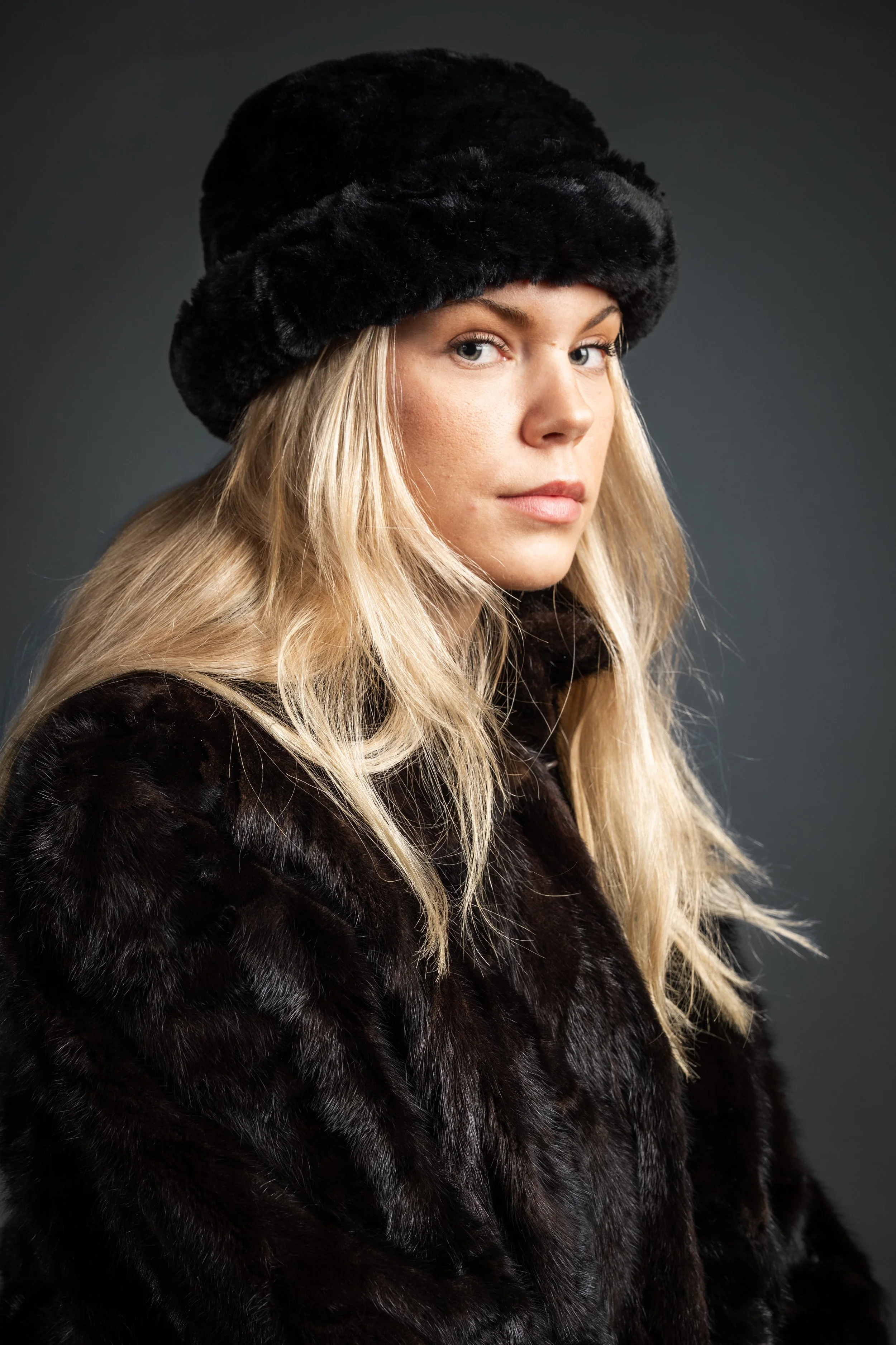 Nuori vaaleahiuksinen nainen yllään turkki ja päässä turkkihattu