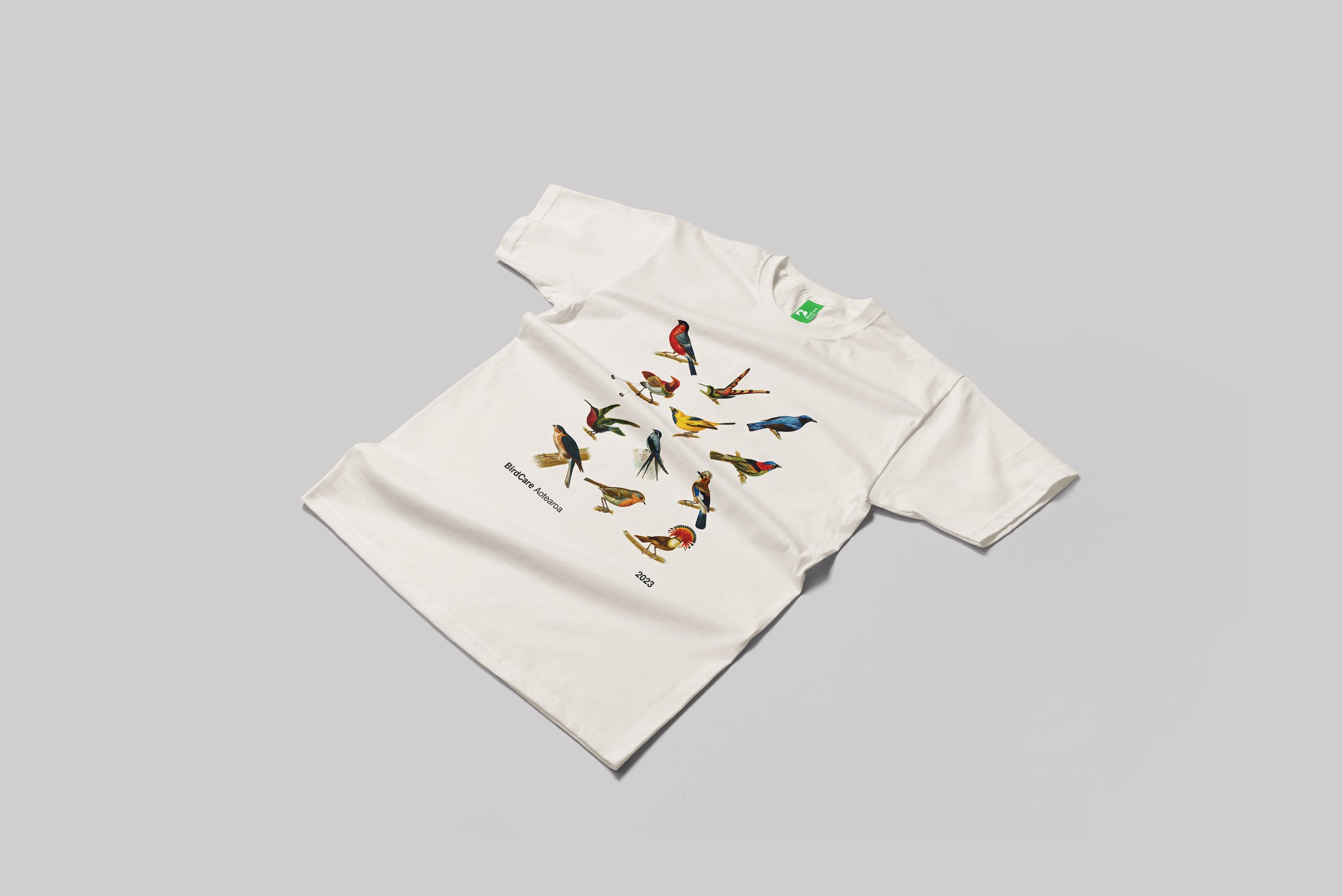 White T-shirt with a colorful bird illustration and text reading BirdCare Australia 2023 on the front.