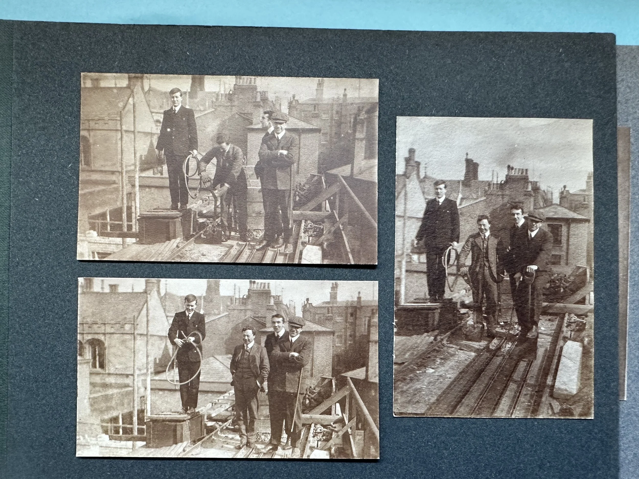 Four men on a rooftop during building works (Cambridge, probable). MBHPC