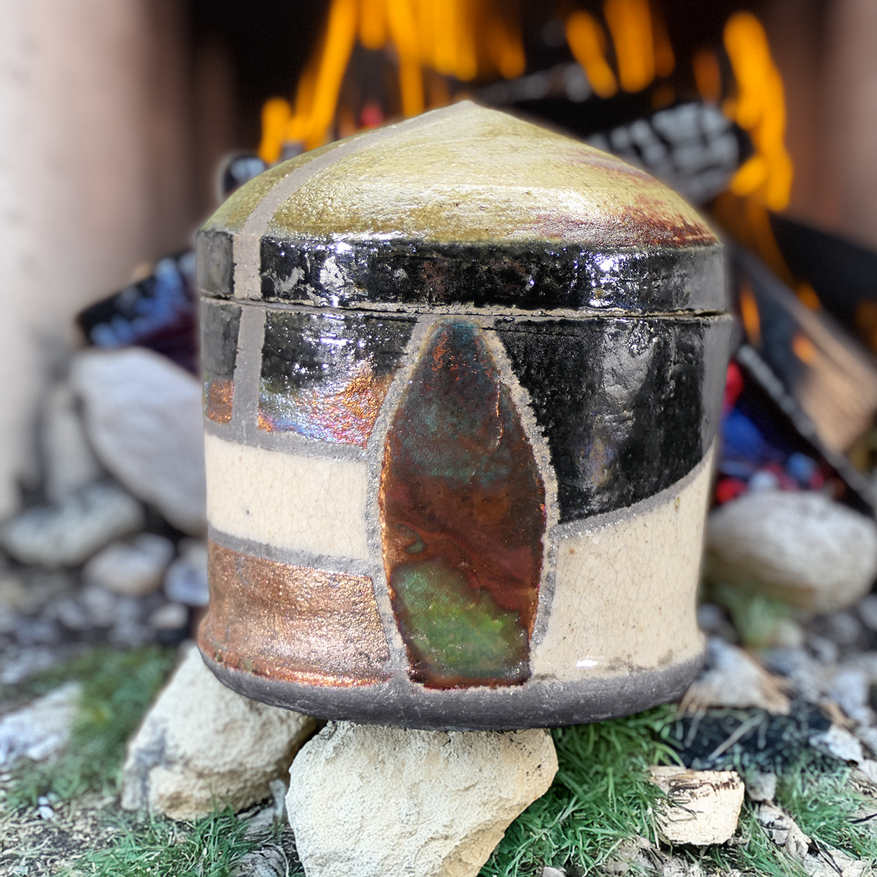 Raku jar with copper focal with fire in background.png