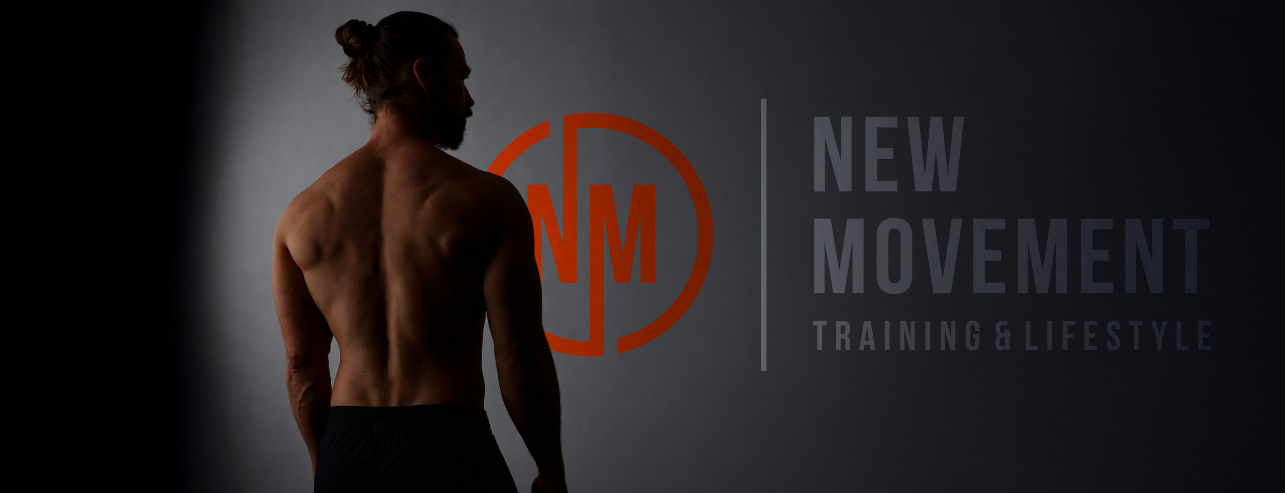 A shirtless man with a bun hairstyle and a beard looking to the left, standing against a dark gray background with a logo and text promoting a new movement, training, and lifestyle.