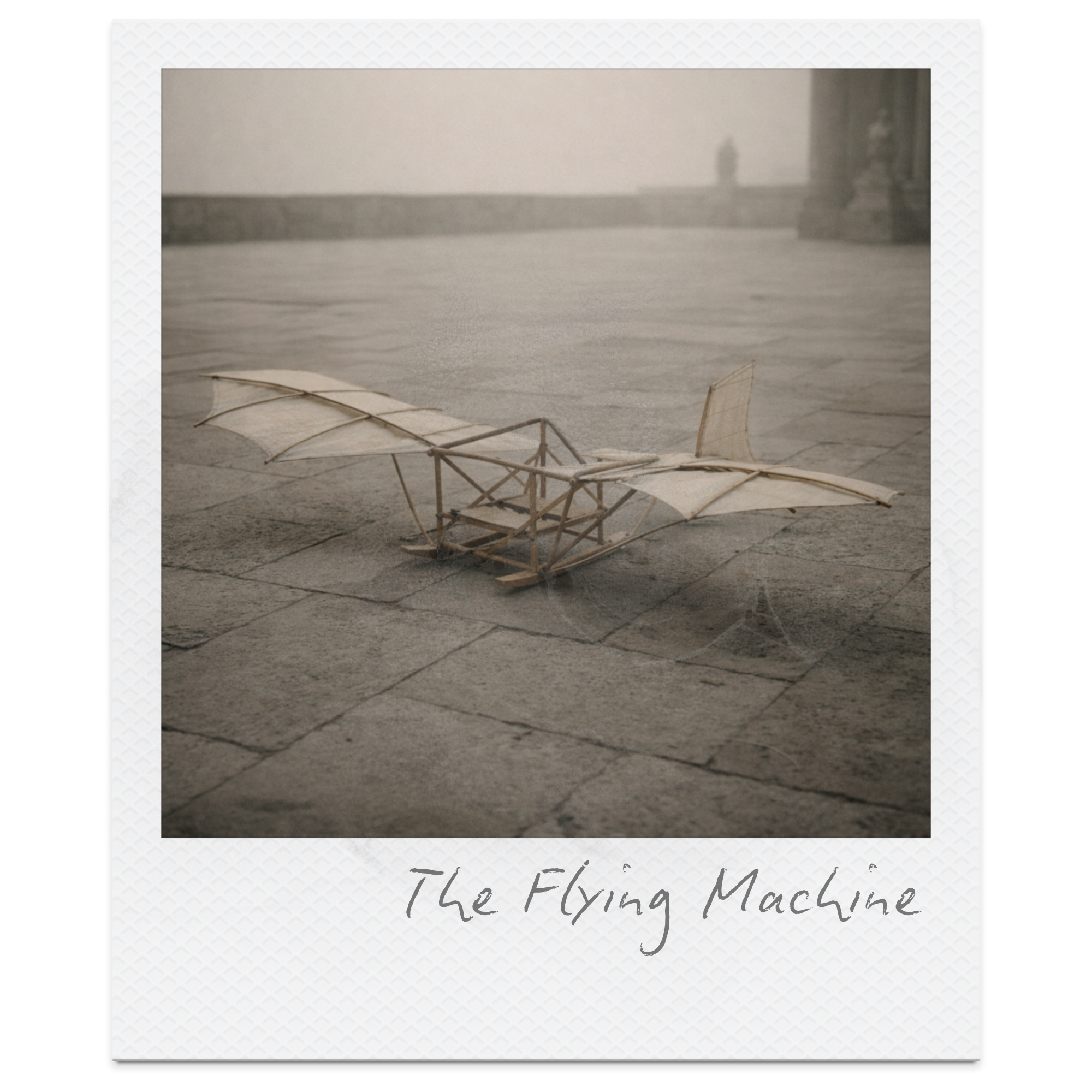 A small model of a flying machine with wings and a wooden frame, placed on a stone pavement with a foggy background.