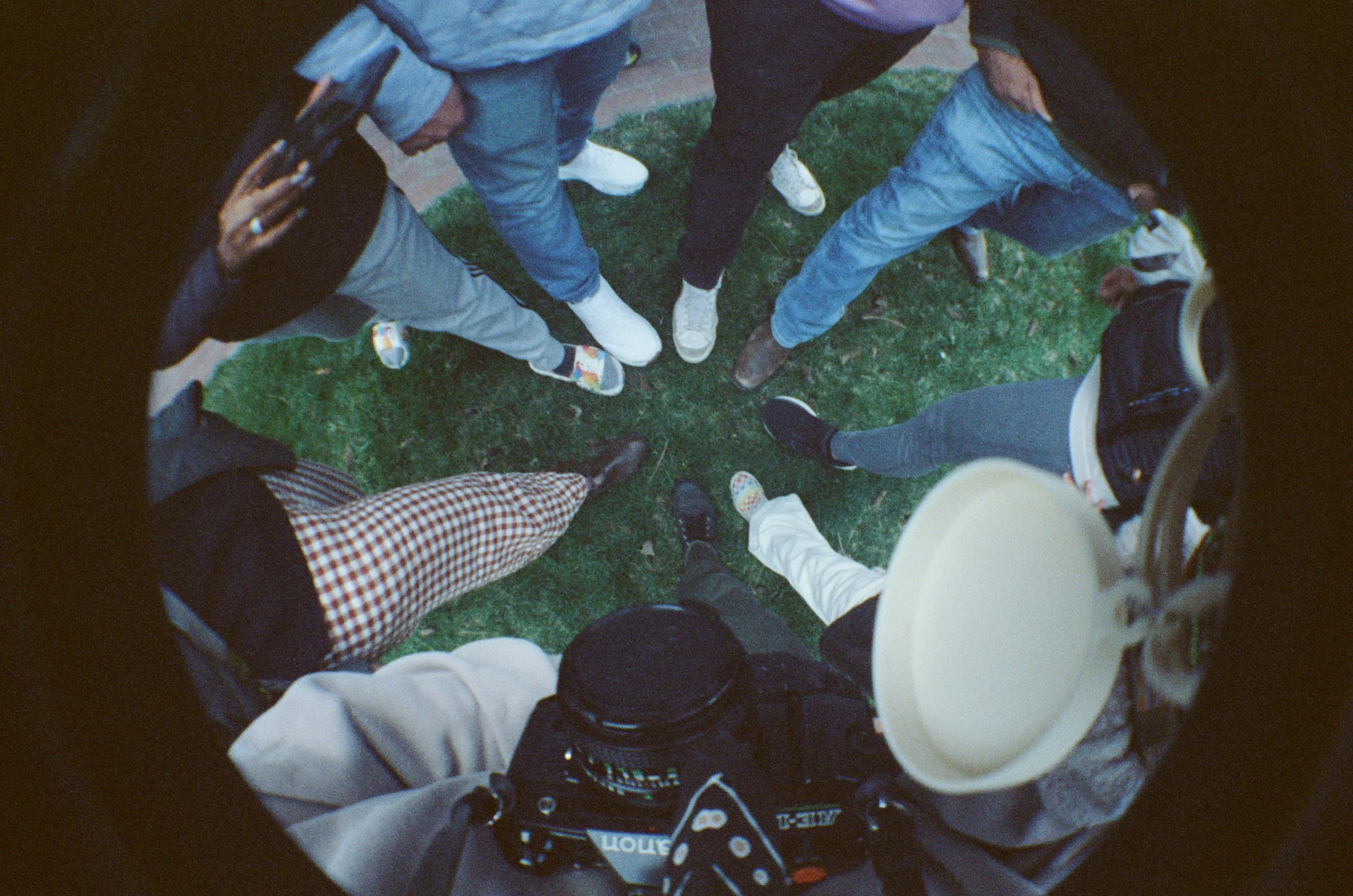 Fish eye photo of peoples feet creating a circle.