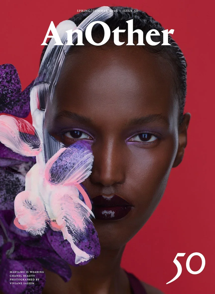 A woman on the cover of a magazine with her hair back, surrounded by flowers, on a red background.