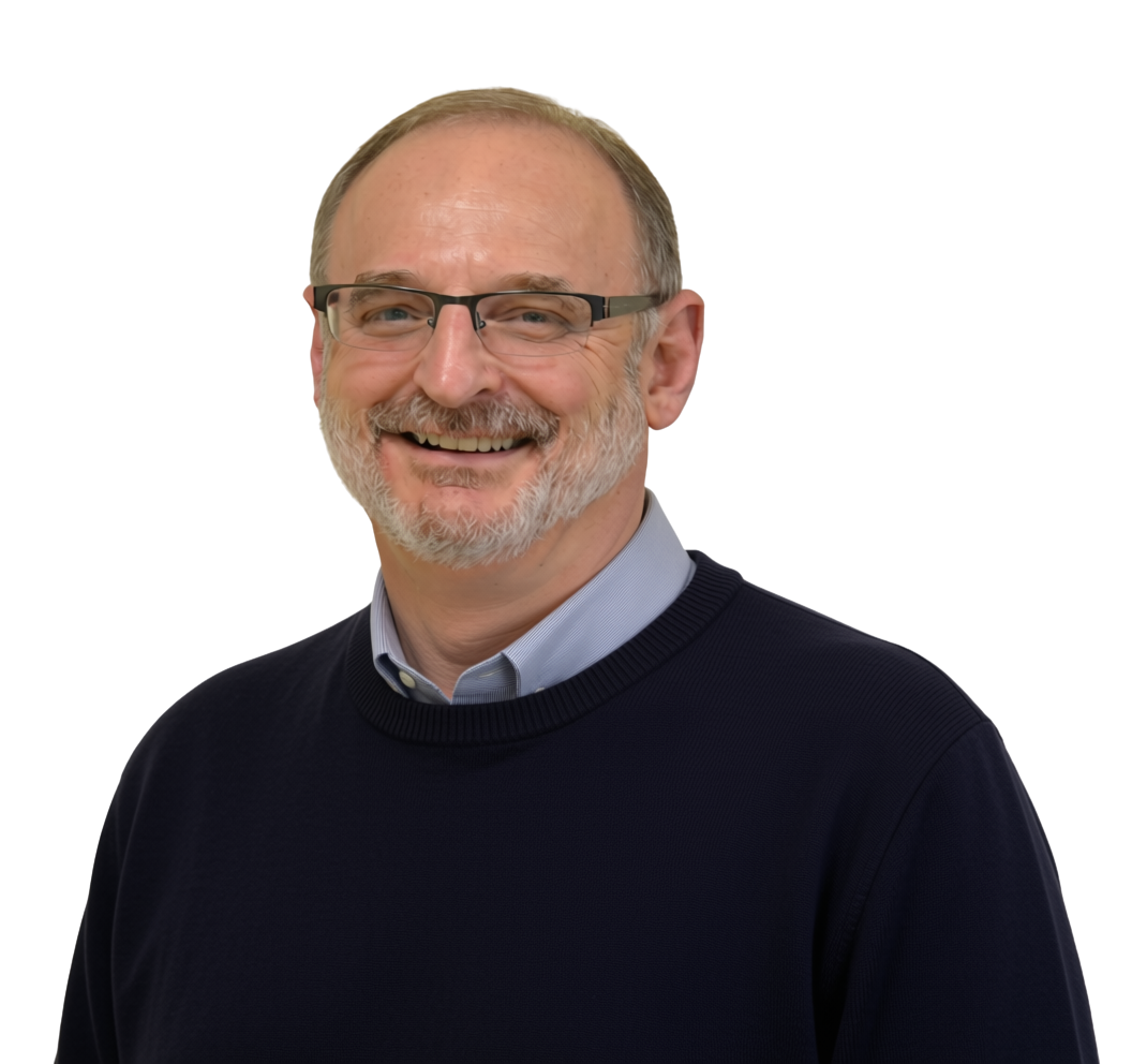 A smiling middle-aged man with glasses, a beard, and a mustache, wearing a blue collared shirt under a navy sweater.