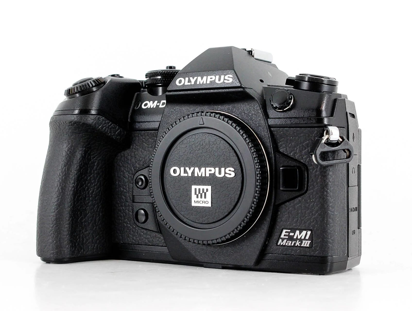 Black Olympus E-M1 Mark III camera with lens cap on, on a white background.