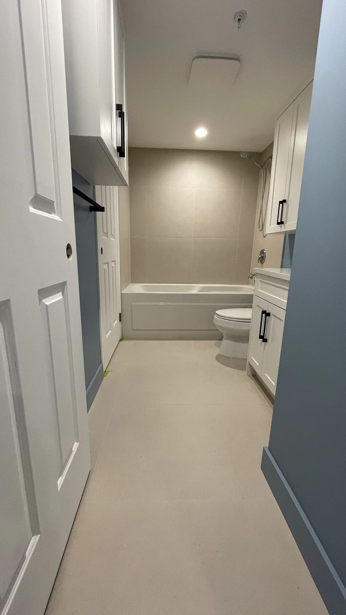 New and completed bathroom renovation with white cabinets and blue walls