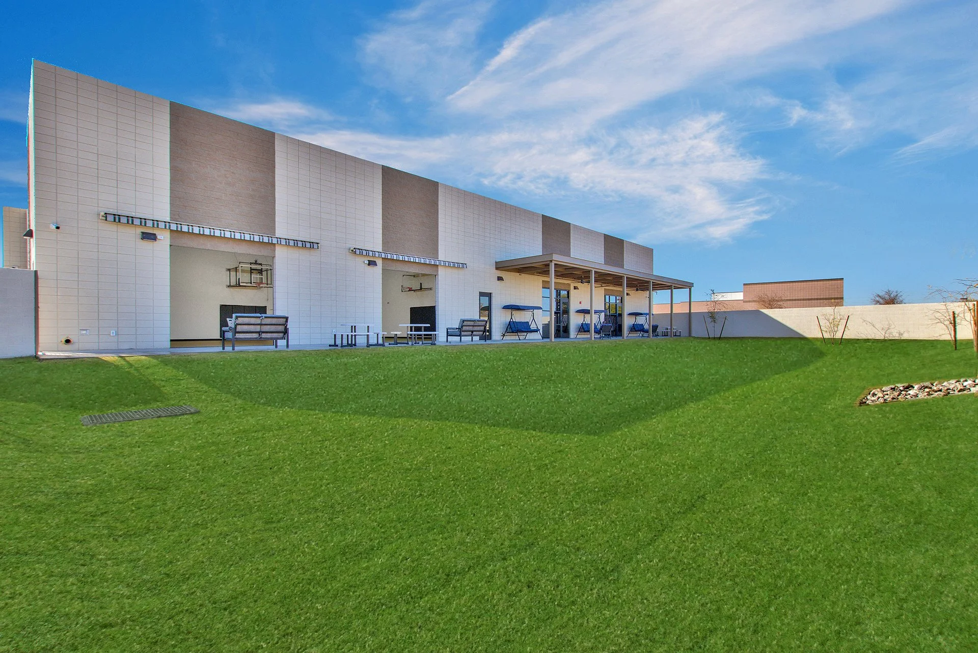 Modern adult daycare building for Neely House with outdoor seating areas, and a green lawn under a blue sky.