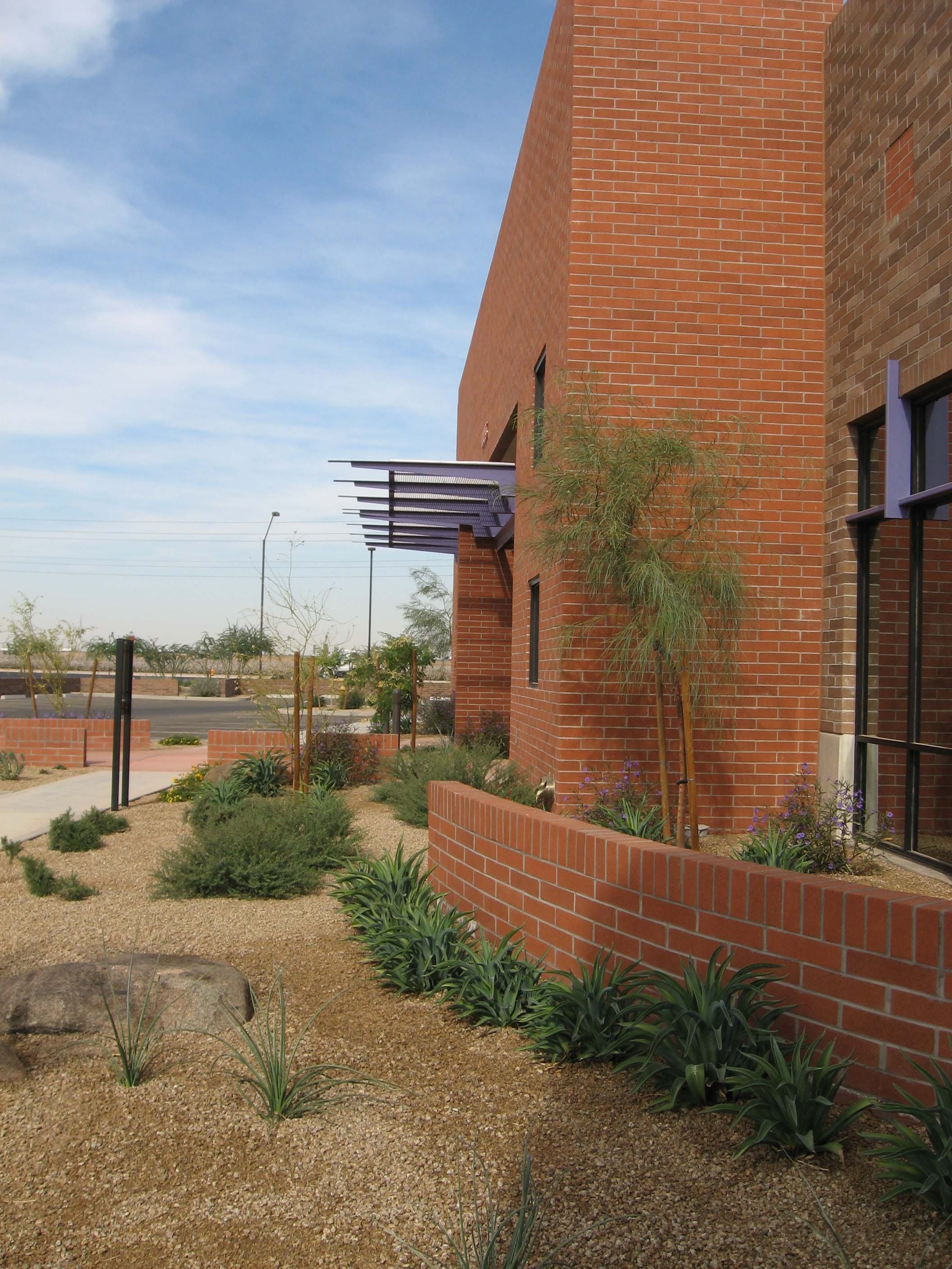 Exterior of brick building with desert landscaping