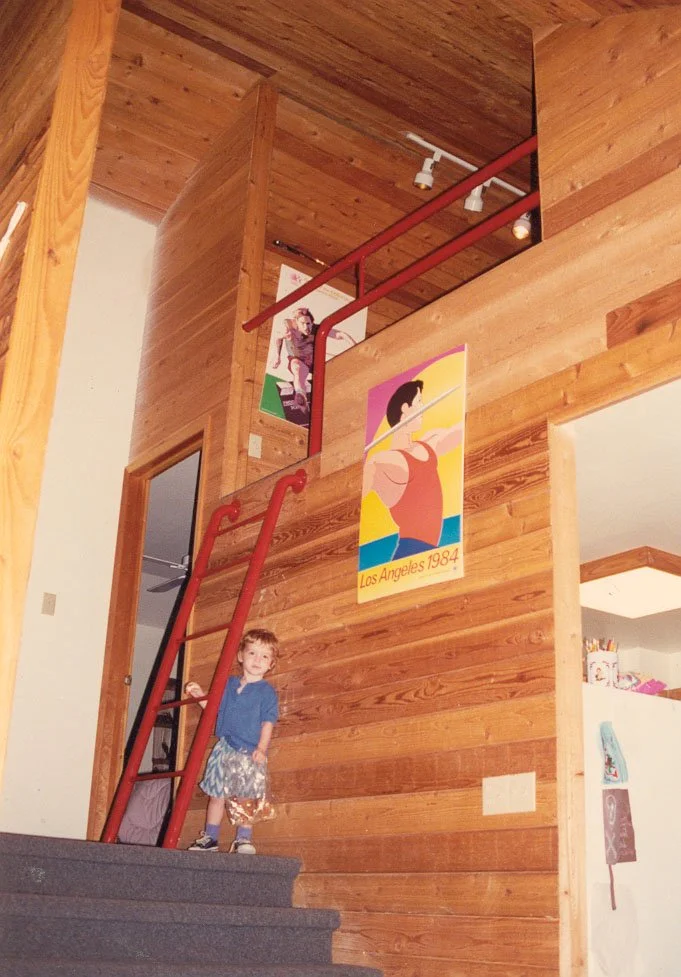 Interior of a wooden house with a red staircase.