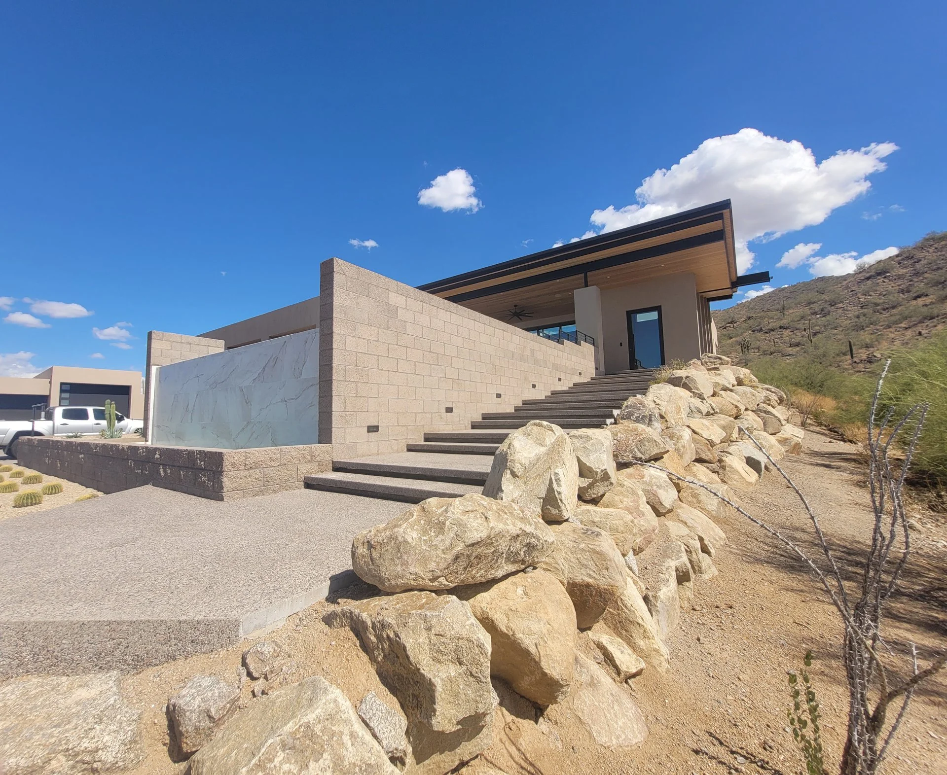 Modern desert home with stone steps along a wash.