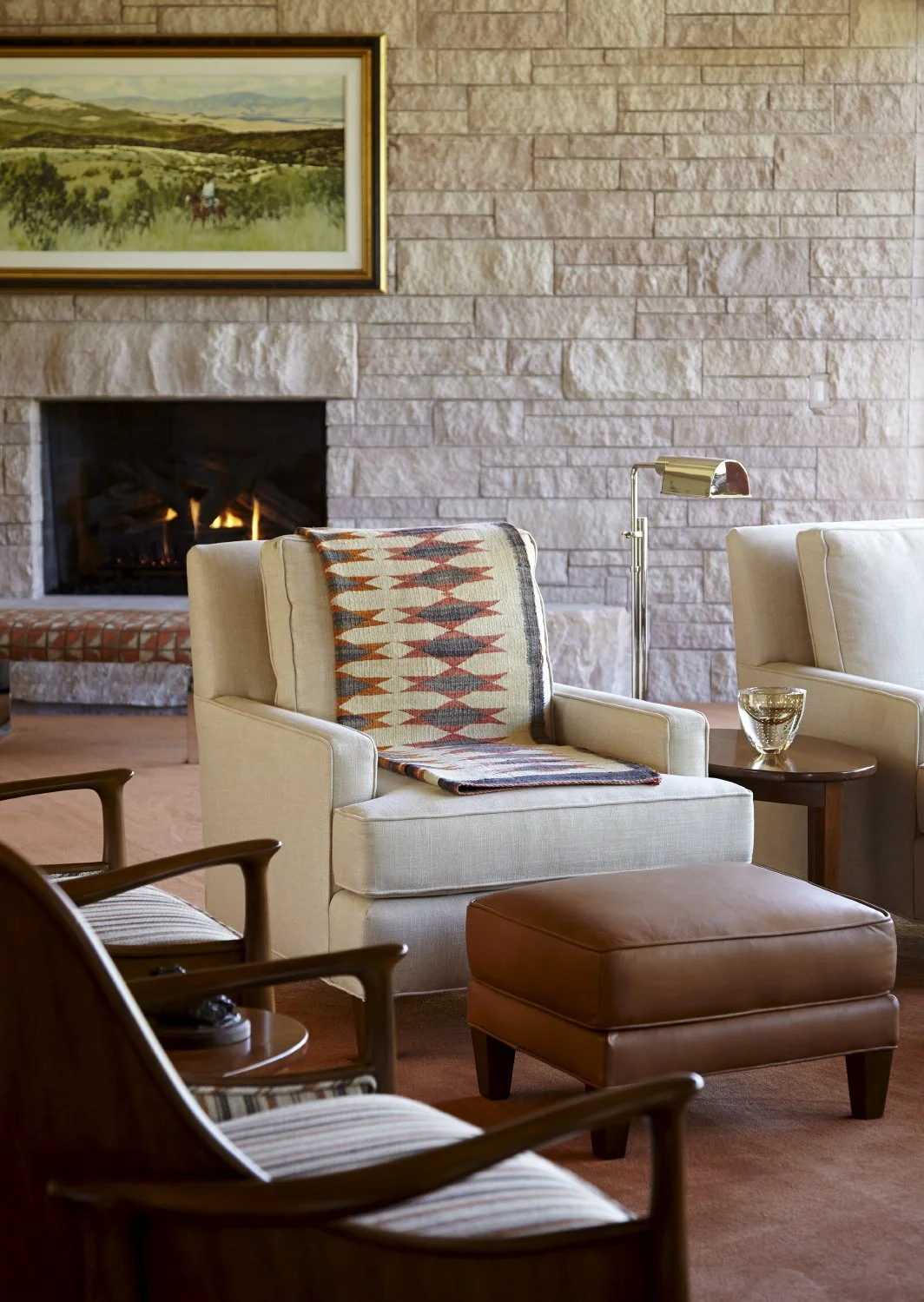 Cozy living room with comfy furniture, and a stone masonry fireplace.