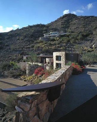 Stone house in desert landscape with surrounding mountains